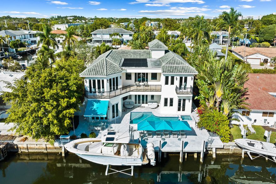 Contemporary tropical oasis situated majestically on  deep water in East Boca Raton. This coastal estate features remarkable craftsmanship with sophisticated interior design. Sprawling 20 foot plus ceilings greet you as you enter this fairytale home. The elegant open concept boasts an updated lavish kitchen. A newly installed and expanded pool deck, freshly renovated and redesigned pool, newly installed batter piling on Seawall, and a newly installed 20,000 lb boat lift, complete the waterfront experience.  A marble staircase and elevator lead you to the second floor with never ending water views. The thoughtfully planned  master bedroom includes a sitting area for a morning sunrise relaxation, a resort like spa bath, and expansive balcony views. Impact glass,
