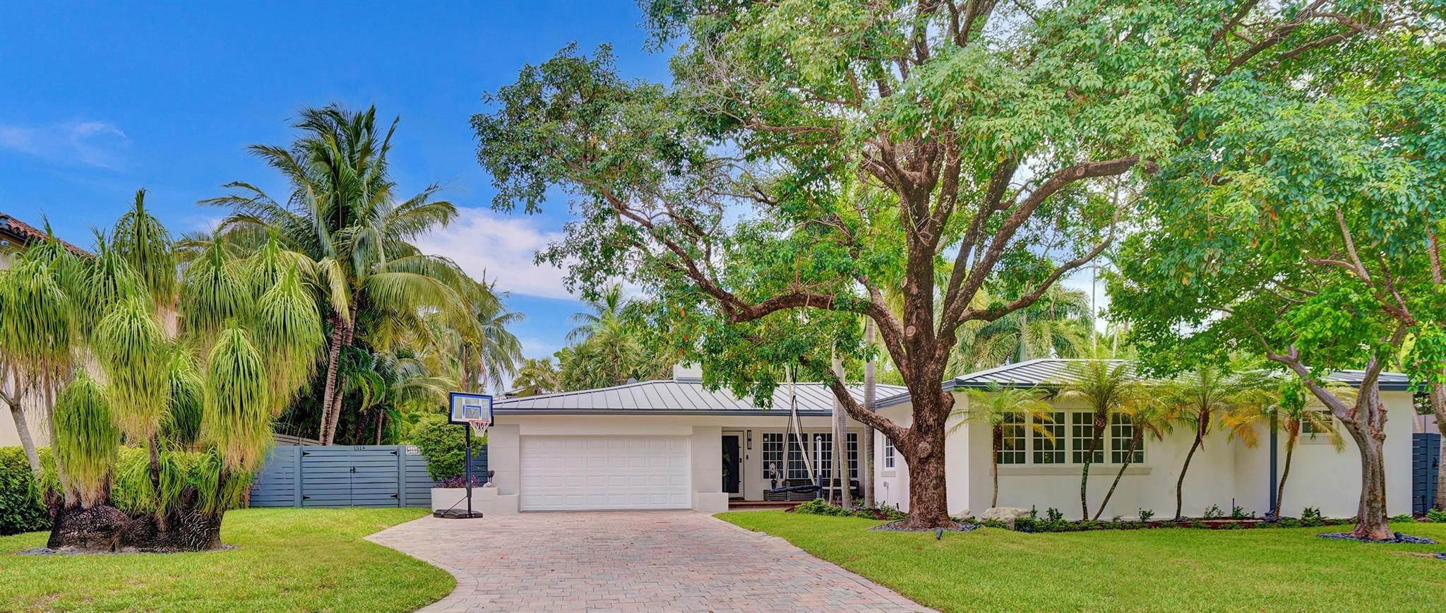 This beautifully remodeled 3 bed | 3 bath | 2-car garage + office home offers 2,704 sq. ft. of interior space on an oversized 11,821 sq. ft. lot (0.27 acres). A blend of classic charm and modern design, it features a spacious open layout with a formal living room with a gas fireplace, dining and breakfast area, a gourmet chef's kitchen with Sub-Zero, Wolf range, quartz countertops, and waterfall island. Built in 1952 and expanded in 2007, with a primary suite includes a spa-like bath, walk-in closet & private office nook. The modern resort-style backyard offers a saltwater heated pool, pergola, paved patio areas, artificial turf & lush landscaping. With impact windows & doors, French doors, plantation shutters & a metal roof. Minutes from the beach, Las Olas, and Bayview Elementary School.