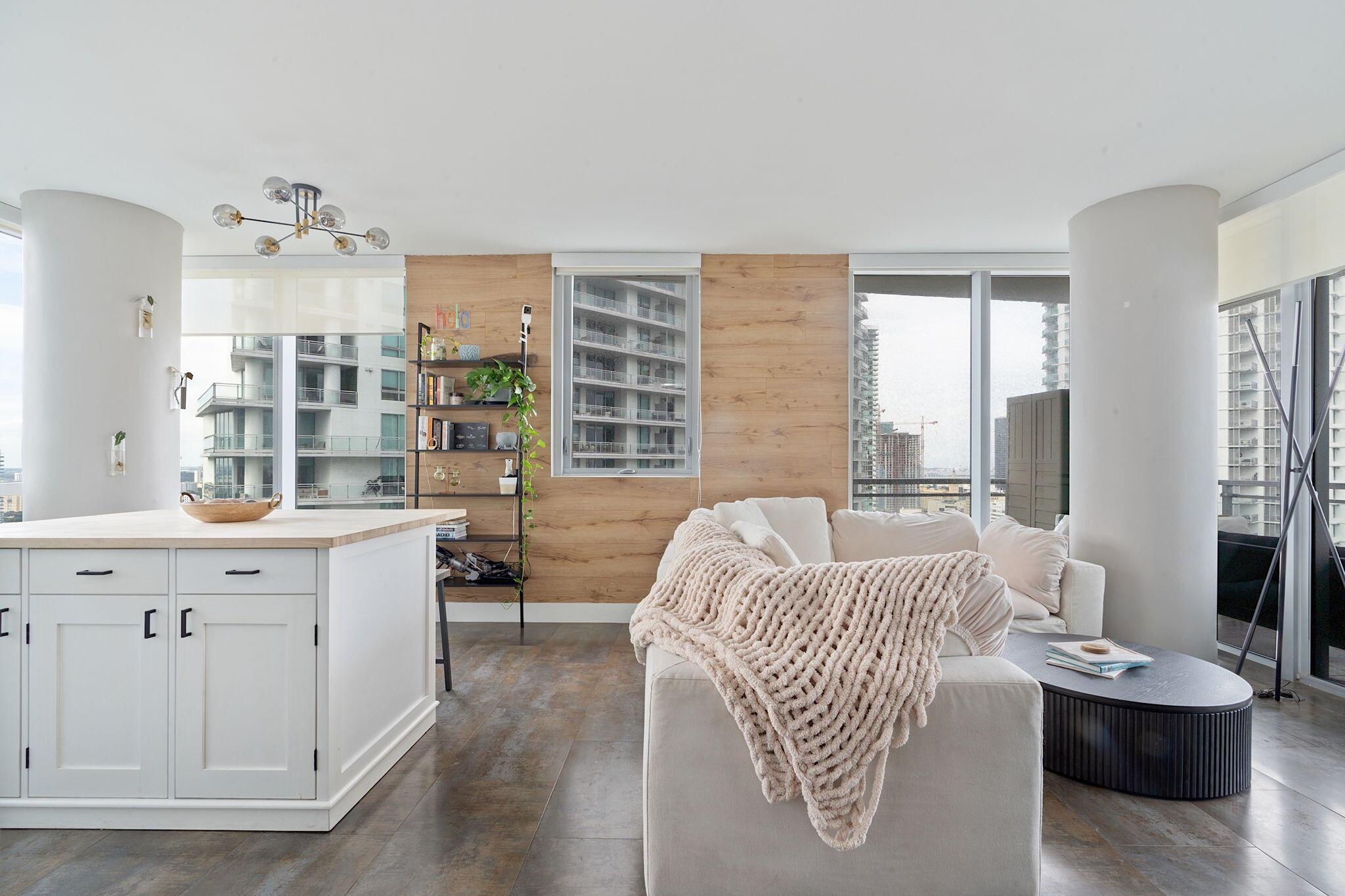 Completely renovated 2BD corner unit with stunning views overlooking Brickell and the Miami River. From wooden accent walls to chic light fixtures, the unit exudes modern luxury. The beautiful kitchen combines high-gloss cabinetry with both wooden and black countertops to create a sleek look. Located on the 31st floor, enjoy the breeze at sunrise with eastern-facing balcony views. The windows span west, north, and east, offering panoramic city views. In the primary bedroom, an abundance of natural light floods through sliding doors that open to a private balcony. The light extends into the gorgeous primary bathroom, where a frosted glass shower wall looks onto the room. The second bedroom also features an ensuite bathroom.The unit is in a modern, renovated building called The Mint