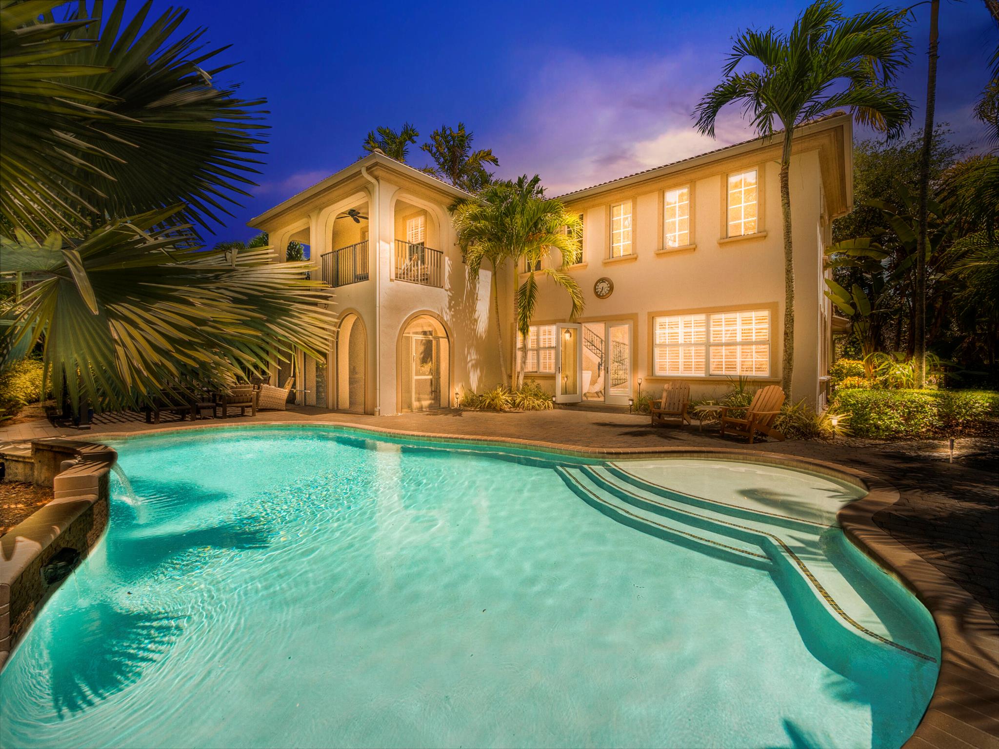 Discover refined coastal living in this 4 bedroom, 3.5 bath residence perfectly positioned within the gated resort community of Evergrene in Palm Beach Gardens. Blending timeless design with modern comfort, this home offers 2,857 sq. ft. of elegant living space surrounded by lush tropical landscaping.Step through the double doors into a bright, open floor plan featuring volume ceilings, crown molding, plantation shutters, and French doors that invite the Florida sunshine indoors. The chef's kitchen is the heart of the home with granite countertops, custom wood cabinetry, stainless steel appliances, and a center island, ideal for both family living and entertaining. The spacious great room flows seamlessly to the outdoor oasis where a heated saltwater pool and spa create a private