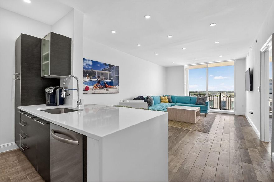 This completely reimagined one-bedroom residence at CityPlace South Tower offers high-end finishes, exceptional light, and one of the largest balconies you'll find in a 1-bedroom downtown. Updated from top to bottom, the home features wide-plank, wood-look tile flooring throughout and recessed lighting that makes the entire space feel light, bright, and airy. The kitchen is a showstopper, with quartz waterfall countertops, sleek custom cabinetry, upgraded appliances, and a modern backsplash, perfect for both everyday living and entertaining. The bathroom has been transformed into a spa-like retreat with floating vanity cabinetry, gorgeous tilework, and a walk-in shower in place of the original tub. The spacious bedroom is complemented by a custom-built walk-in closet with tailored