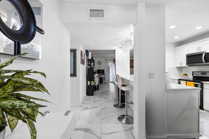 Luminous 2/2 condo in the highly desirable La Placida community of Coral Springs. Beautifully renovated & one of the most tastefully updated units. A bright foyer entry welcomes you into a light-filled interior featuring 24×24 tile flooring throughout, knockdown textured walls, and recessed kitchen lighting. The open kitchen is fully upgraded with quartz countertops & backsplash, shaker-style white cabinetry with crown molding, stainless steel appliances, & a raised counter with additional seating. The spacious primary suite offers dual closets and a stunning ensuite bath with floor-to-ceiling tile and glass shower doors. The guest bath features matching Italian tile and glass enclosure. Impact sliding doors, hurricane shutters, & a private screened patio complete this move-in-ready home.