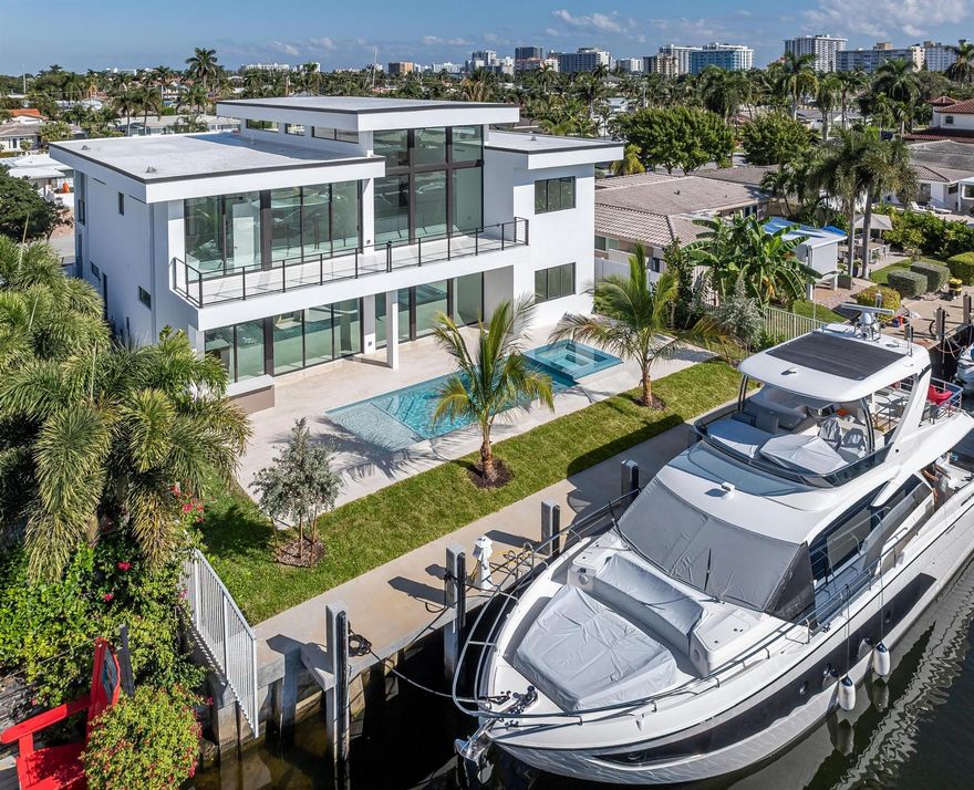 Brand-new modern two-story waterfront home offering the South Florida lifestyle that you dream about. Thoughtfully designed with floor-to-ceiling glass, a steel/wood/glass floating staircase, 4x4 porcelain stone flooring and water views from nearly every room. The chef’s kitchen features Sub-Zero and Wolf appliances, matte-gold fixtures, a 5x10 island and wet bar. The 5BR/5BA/2-car garage layout includes a stunning owner’s suite with dual balconies, spa-style bath, tastefully designed walk-in closet and serene waterway vistas. Outside, enjoy generous space to entertain,  a 17x32 pool, spa, gorgeous landscaping, foliage/greenspace (flowering trees, palms and clusia), privacy fencing, full summer kitchen and new 75' dock (currently hosting 62' Azimut). A refined waterfront estate ready now.