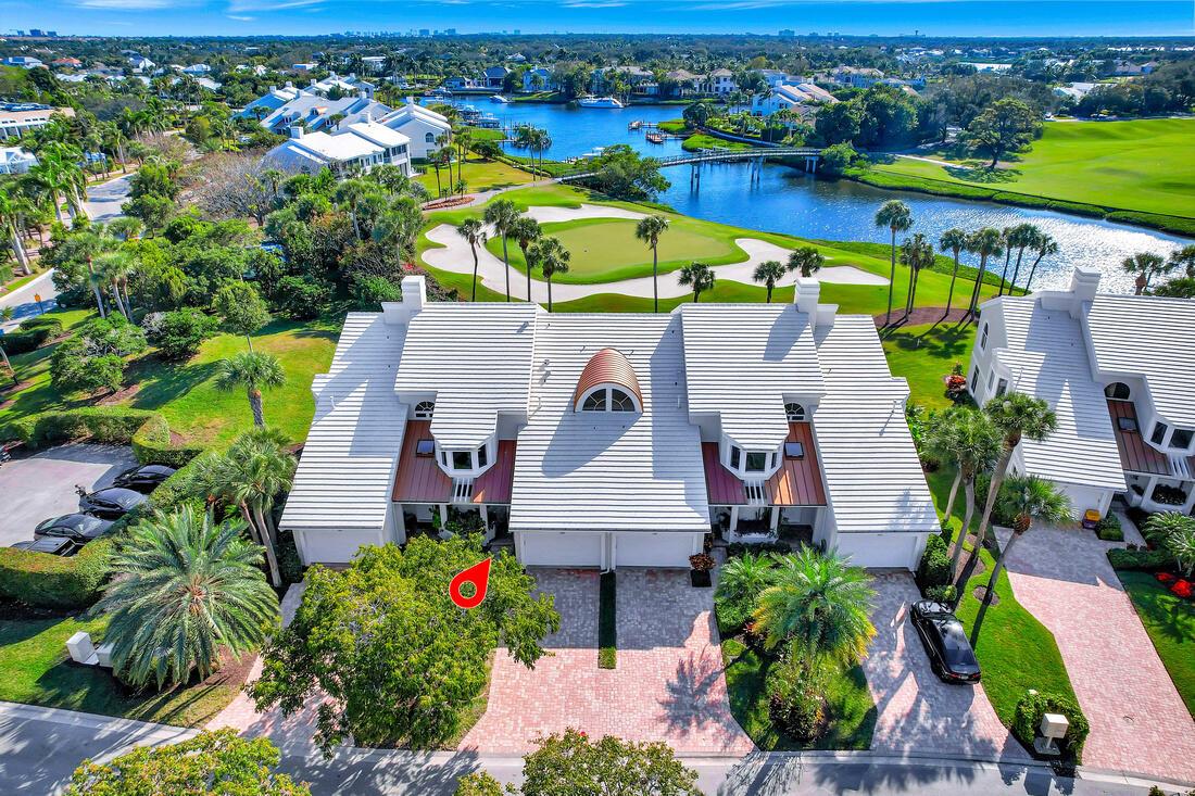 Perched above the 18th hole fairway and green, this impeccably renovated Harbor Home boasts stunning southern exposure and a forever view that captivates. The contemporary interior features impact windows and doors, elegant wood flooring throughout, and custom floating cabinetry. The open-concept Bosch kitchen dazzles with back-painted glass cabinets, porcelain countertops, a wine cooler, an induction cook-top, and a breakfast bar, making it as functional as it is stylish. The thoughtfully modified floor plan enhances the flow, including a reimagined entry to the primary suite, expanded closet space, and a luxurious bath with marble flooring, a freestanding tub, and dual sinks. Additional highlights include a private elevator, electric shades, and a private dock accommodating boats up to