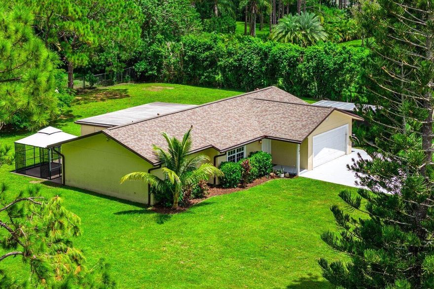 WELCOME HOME to serenity and (1.31) acres of country living! This beautiful Lennar built home is priced 39K below a recent certified appraisal and features (3) bedrooms, plus a 16' x 11' bonus room, (2) baths, (2) car garage, 2020 roof, renovations and upgrades throughout, hurricane impact windows and doors, paved road and this beauty defines excellent location! ENTERING you will discover that this gem is resting on a premium fully fenced corner lot and the front door brings you inside where you are greeted by an open floor plan, spacious foyer with bead board, 10' vaulted ceiling, ceramic tile with 5 ¼'' baseboards throughout the common areas, high quality flat wall finish and so much more! PASSING THROUGH you will find a totally renovated and  (CLICK) upgraded kitchen boasting granite counter tops, stainless steel appliance package and a five person bar. Renovations throughout, high hat lighting, upgraded baths, crown molding and chair railing throughout and (every) bedroom has its own walk-in closet and new waterproof laminate flooring. And hello master suite featuring an enormous 11' x 11' walk-in closet/storage area with wall to wall built-in cabinetry and lovely barn door leading you into the master bath where you will find a spacious walk-in shower and linen closet. You will also discover a 16' x 11' bonus room with loads of potential and under AC front loading washer and dryer. STEPPING OUTSIDE brings you to a 12' x 12' concrete slab, oversized concrete driveway, whole home gutter system, plush yard with countless mature trees and is simply, a perfect space for privacy, relaxing, family gatherings, entertaining, outdoor fun and building a pool, guest home, shop or chicken coop. HELLO SAVINGS, PEACE OF MIND AND CONVENIENCE... Incredibly low homeowners insurance quote for less than $4000 per year, qualifies for over $3200 in insurance discounts and is not located in a flood zone, 2020 roof, hurricane impact windows and doors, 30 amp RV hook up, convenient commuting and is located on a dead-end street. LOCATION LOCATION LOCATION! This gem is tucked away in the MOST sought after area of The Acreage, with shopping and dining just around the corner and nine quaint parks with countless year-round outdoor activities such as free concerts at the community amphitheater, play grounds and picnic areas with grill pavilions, fishing, skate and equestrian parks, fitness and equestrian trails, football, baseball and soccer fields, tennis, basketball, volleyball, pickleball and racquetball courts and is located just minutes to everything one could possibly desire: Florida's Turnpike, I-95, Palm Beach international Airport, arts, entertainment, world class equestrian shows and facilities, beaches, theater, golf, business and economic development, education, green living and much more! COME AND SEE why The Acreage/Loxahatchee is very sought after and take in the fresh country air and peaceful sounds of nature. Bring your toys, pets or just about anything your heart desires... The possibilities are endless and there is no HOA! Come and enjoy your life away from the hustle and bustle and your evenings gazing at the stars. Hurry and be sure to check out the VIP buyer discounts on site.
