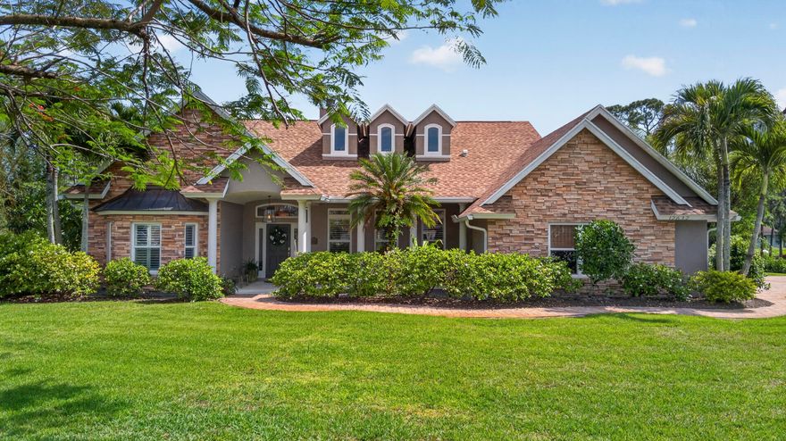 Welcome to your own private tropical retreat in The Acreage! Located on paved Citrus Grove Blvd near Northlake Blvd, this lovingly maintained CBS pool home sits on 1.19 acres with no HOA & wonderful neighboring homes. Built by the original owners, this gorgeous one-level residence offers 3BRs+office, 3BA, formal LR, DR & FR, 2.5-car garage, and an inviting layout designed for everyday comfort & entertaining. As fabulous as the interior is, you'll want to spend all your time relishing in the stunning outdoors. Major updates include a 2023 roof, PGT impact windows/doors- 2019, 2 AC units- 2018, tankless WH- 2024, Ox Floors garage coating- 2024, fiber optic service & beautifully refinished hardwood floors in 11/2025. The fantastic kitchen features a gas stove, double ovens, granite c-tops, pass-thru window to the lanai and a seamless connection to the main living areas, enhanced by plantation shutters & a double-sided gas fireplace. The primary bath was recently renovated, including the addition of a free-standing soaking tub, for a fresh, elevated feel. The second bath was also updated. Step outside and fall in love with the resort-style backyard with southern rear exposure. The heated saltwater pool with a raised spa just had a major makeover! The pool was just resurfaced and complemented by a brand-new pool deck and patio, creating the perfect setting to relax, entertain, and enjoy your own piece of paradise. The seller also added electric storm screens to the patio in 7/2025. With room for toys, boats, RVs, gardens, and more, this property captures the best of Acreage living- space, privacy, luxury, and convenience near parks, ball fields, library, dining, shopping, and future growth around Avenir.