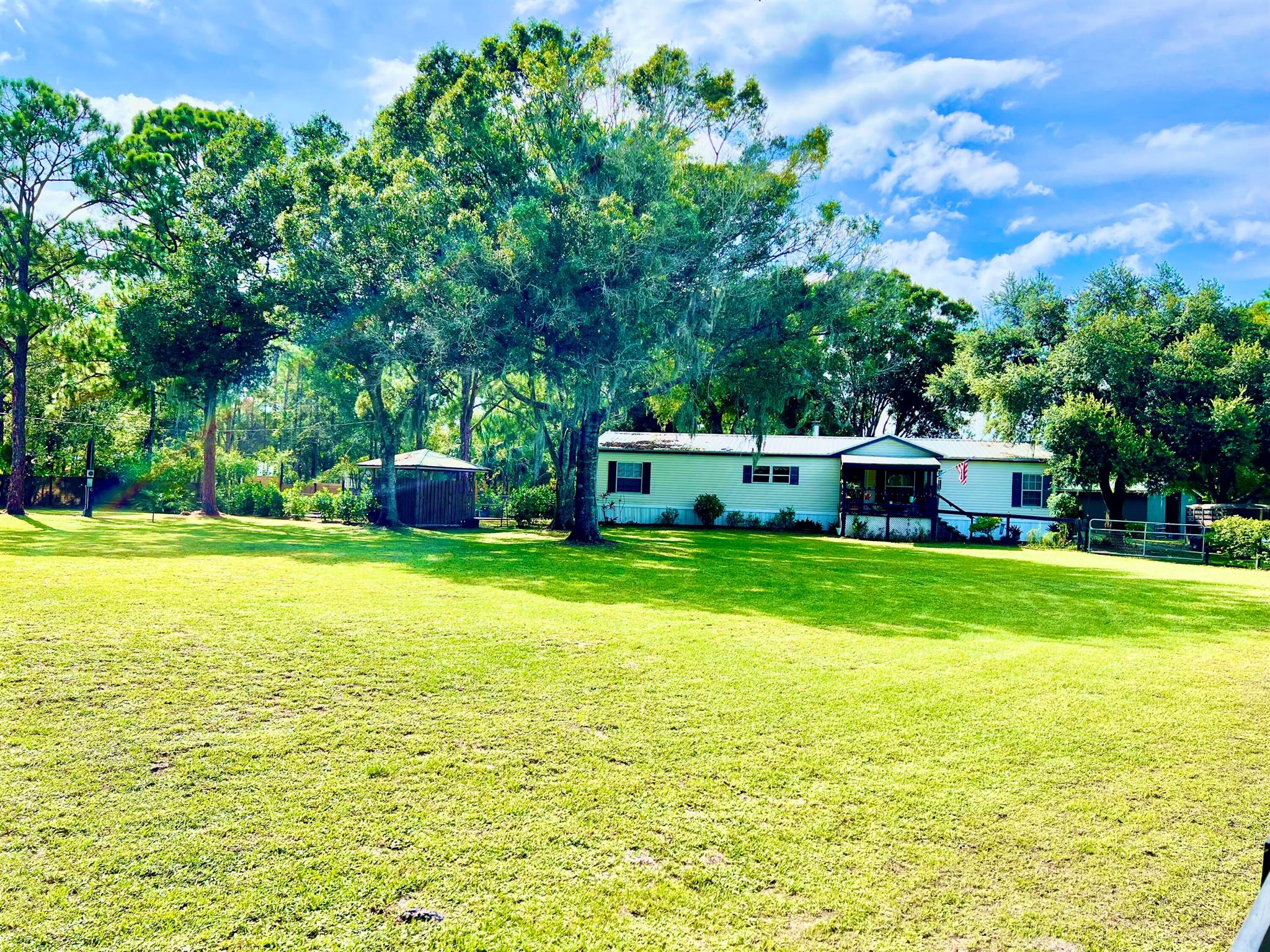 Beautiful real property designated MH on 4.96 acres with 2 large horse barns including 8 total stalls and 2 tack rooms, dog kennels, paddocks and 5 pastures all fenced and connected by gates. Open floor plan no wasted space, laundry room, fireplace, porches, extra large primary bedroom, ensuite and walk in closet. Each of the five back stalls has a paddock and turn out if you'd like to lease stalls for income. The front barn has 3 large concrete stalls with paddock and private turnout. 5 pastures all high and dry and cross-fenced but with gates for nearly full access, fenced dog yard and kennels. Whole house generator and water system, newer metal roof, hot water heater, AC and ductwork, appliances remain.