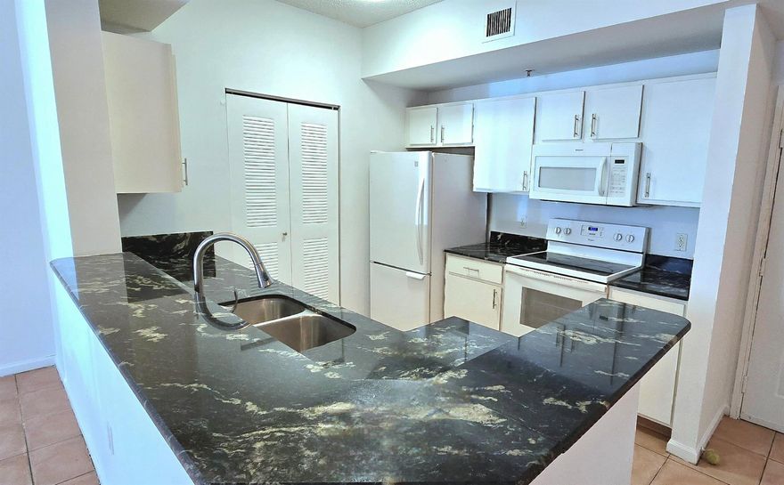 Live the Intracoastal lifestyle in this gated, resort-style community! Beautifully upgraded 1st-floor 2BR with private patio, close to the clubhouse and private beach. Granite kitchen with extended bar. Spacious open layout, great room style, volume ceilings, tile floors and full-size washer/dryer inside condo. Large master with walk-in closet. Bath features a granite vanity and tub. Secure lobby with camera. Enjoy amazing water views from the clubhouse with heated pool, spa, sauna, gym, billiards, BBQs, tikis and private beach. Kayak storage available for a small fee. Adjacent to Palm Beach Yacht Center for boat club and charters. Water + amenities included. Pet friendly!