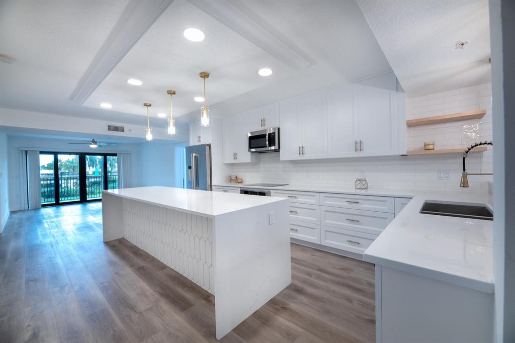 Completely renovated highly desirable Marina at the Bluffs 1st floor condo. Gorgeous 2 bedroom 2 bath. Designer custom kitchen with built in cooktop and oven, large professional refrigerator and wine cooler, marble look quartz countertops with waterfall edge, sit in island with overhead pendant lighting, artisan tile backsplash. Reconfigured dedicated dining room. Master bathroom has floating shower bench and floating vanity. Custom closets and barn doors. Laundry room with custom cabinets and shelving. Beautiful engineered vinyl plank flooring throughout. Large screened in patio with private entry to pool area. Impact doors throughout, Nest thermostat, a/c 2019. Minutes to the beach, shopping and dining. TURNKEY A MUST SEE.