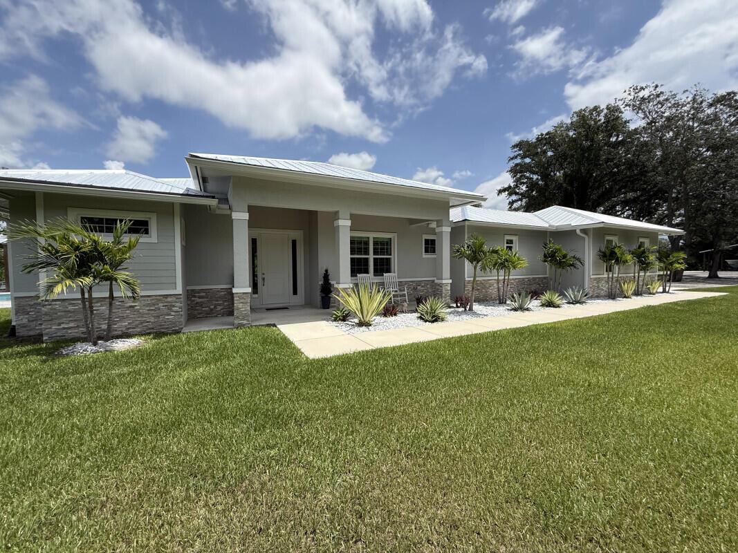 Discover a tranquil waterfront property located in Indiantown, FL on the St. Lucie River that runs to Lake Okeechobee & to the Stuart Inlet. This newly constructed CBS home sits on 2.25 acres and has 900 ft of natural water frontage! A True boater's paradise. Park your boat right behind the house on a 16k lb. Boat lift or bring your Sporty and park it in the day dock! Separately on the property there is a 40x60 pole barn with a 20x40 enclosed garage! Bring all the toys you want here there's no HOA. There is Full electric under the pole barn and in the garage as well completed with RV hook up! This home comes with impact windows throughout & plantation shutters. This home offers 10 ft beam roof with 12 ft Coffered ceilings, outdoor kitchen, reverse osmosis water system, salt system pool,