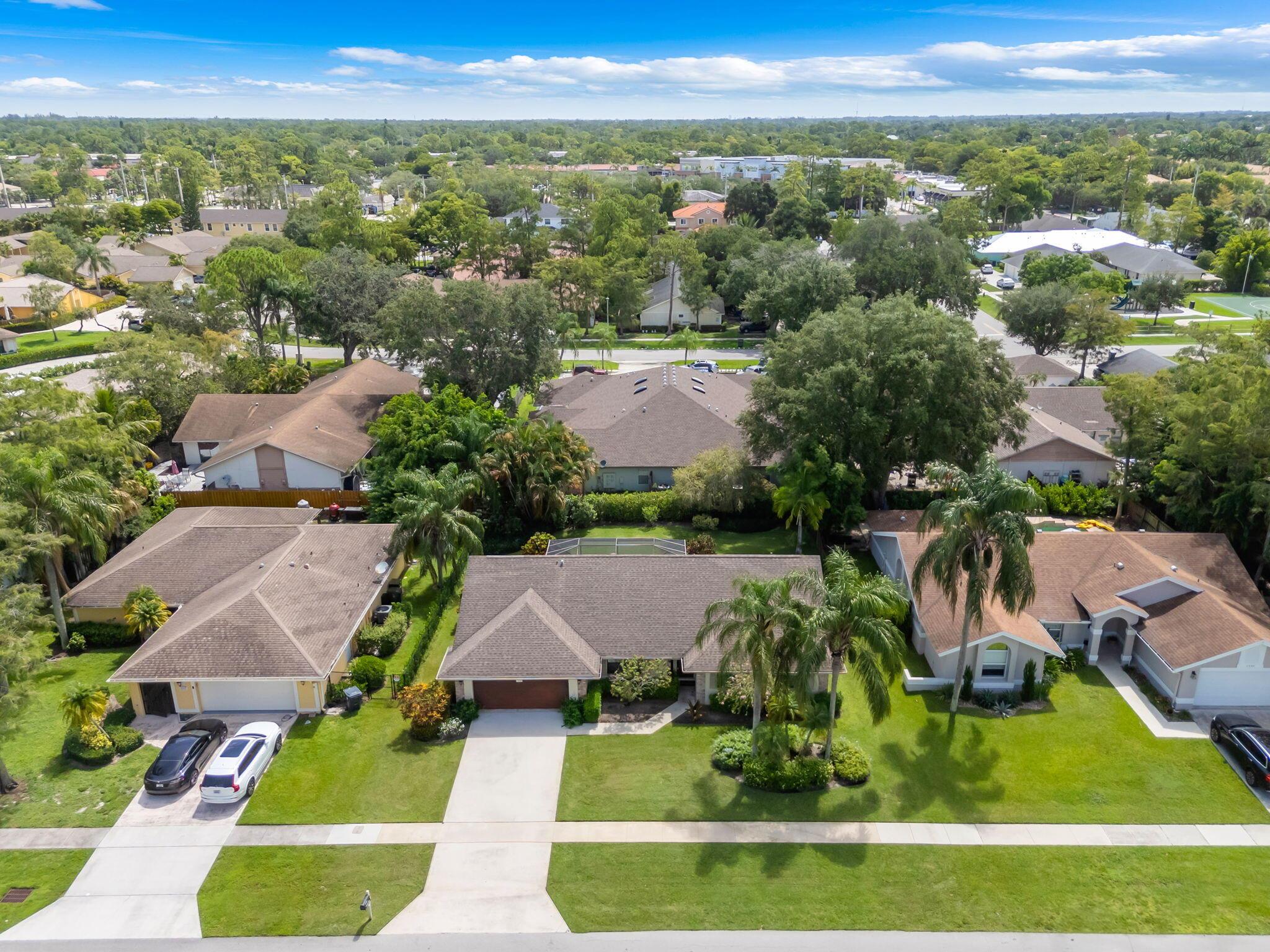 This charming 3-bedroom, 2-bathroom home is ideally located near equestrian facilities. It boasts new PGT windows equipped with hurricane shutters and new hurricane impact doors. The formal living room features new laminate flooring and crown molding, while the dining room has French doors that lead to a screened patio. The spacious kitchen, complete with a skylight and breakfast bar, opens up to the family room, which has vaulted ceilings, a large pantry, and an indoor laundry room. All bedrooms are generously sized and equipped with plantation shutters. The remainder of the home is fully tiled. Additionally, the garage includes a generator hookup.