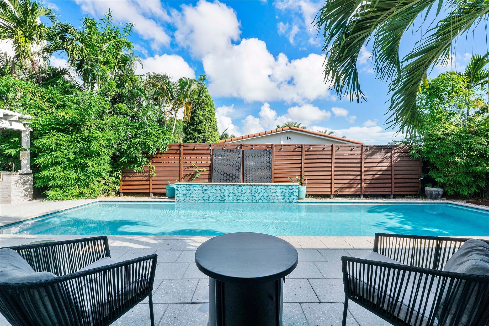 Experience the best of Wilton Manors living in this beautifully updated 2BR/2BA residence, perfectly situated on a large corner lot just a short stroll to The Drive’s vibrant dining, shopping, and nightlife. Currently operating as an Airbnb, the home offers exceptional versatility as both a private retreat and income-generating property. Timeless terrazzo flooring flows throughout, complementing a modern kitchen with sleek finishes and open living spaces filled with natural light. Step outside to your private oasis featuring a saltwater pool, jacuzzi, outdoor shower, and a fully equipped summer kitchen ideal for entertaining. With impact windows and a resealed roof, this property provides peace of mind along with style and function in one of South Florida’s most desirable communities.
