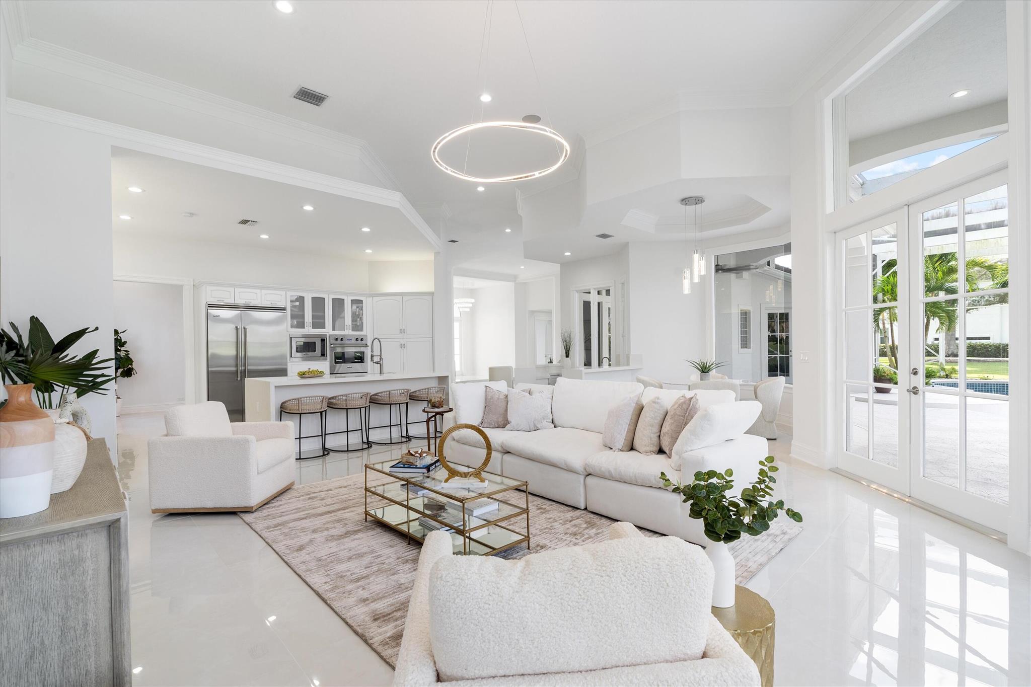 This exquisite modern home boasts 3 bedrooms, an office, 4 1/2 bathrooms, and a spacious 2 1/2 car garage. It is ideally situated within the coveted Ibis Country Club community, overlooking the second green of the renowned ''Legend'' Nicklaus golf course. The residence features an open floor plan that bathes the interior in natural light, characterized by clean, sleek lines and breathtaking golf course vistas. Recently renovated and refreshed, the house exudes an airy ambiance with porcelain flooring, sleek quartz countertops throughout, brand-new appliances, energy-efficient LED recessed lighting, an instant hot water system, and a new roof installed in 2017. The primary suite includes separate his and hers bathrooms, The inviting outdoor spaces create a serene oasis