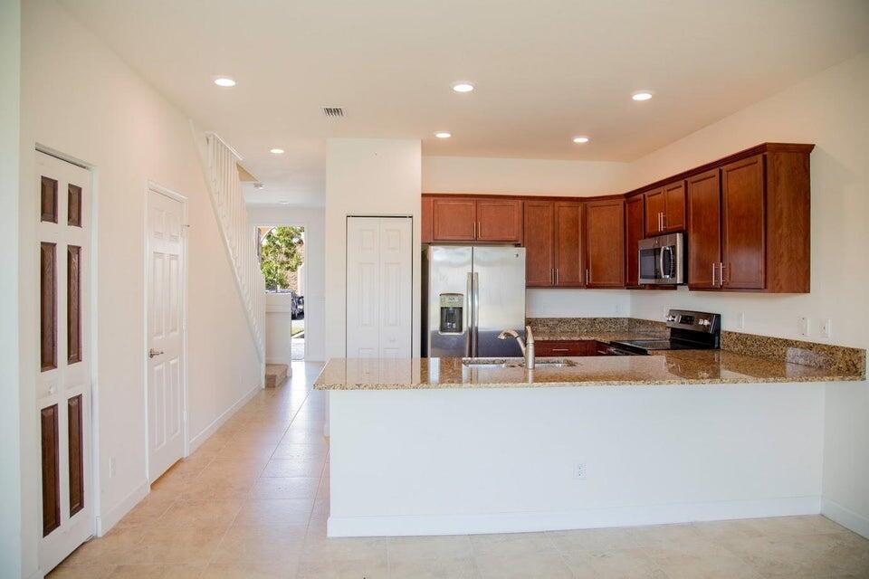 Immaculate & spacious 3 Bdrm/2.5 bath townhouse in gated Charleston Commons. Home is new, clean and bright with value-added LAKE VIEW! Features include modern expresso cabinets, stainless steel appliances and granite countertops. Main floor has 18 inch tile throughout with plush stain resistant carpeting on second floor. Good sized master bedroom with walk-in closet, bath with clear enclosure shower and theatrical-style lighting over vanities. Conveniently located near The Ballpark of the Palm Beaches. Quick and easy access: sandy beaches, restaurants, shopping, cultural venues, int'l airport