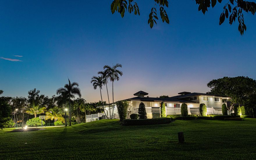 Situated in the sought-after Horse Country of Plantation Acres, this 1.39-acre gated estate offers privacy, space, and refined yet comfortable living with no HOA. The expansive multi-level residence features 5 bedrooms, 4 bathrooms, a home theater, exercise room, and a basement providing flexible space for entertaining, recreation, or extended living. Outdoor amenities include a heated second-level saltwater pool with expansive deck, wraparound balconies, half basketball court, generous lawn areas, and lush tropical landscaping. Additional features include a fresh-water well, soft water system, newly installed generators, and extended driveway parking. Conveniently located near Sawgrass Mills, major highways, FLL, and area beaches.