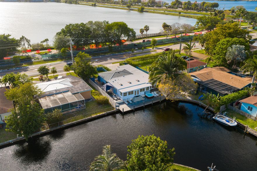 Million-dollar view on an exquisite home featuring 4 en-suite bedrooms, with $575K+ spent on re-construction. Except for exterior shell, everything is new and permitted: metal roof, skylights, hurricane proof windows and doors, plumbing inside & underneath the house, underground FPL service, electrical wiring, lighting, AC including ducts, porcelain floors in common area, solid wood floors in bedrooms, appliances, designer cabinets, granite countertops, glass enclosed showers, custom-made vanities. Complete permitted outdoor redo of $95K+, featuring all new: dock, deck, driveway, irrigation, landscaping, fences, outdoor furniture, jacuzzi. Panoramic back view of canal with ocean access under fixed bridges. Outstanding front view of lake and park undergoing million-dollar city improvements.