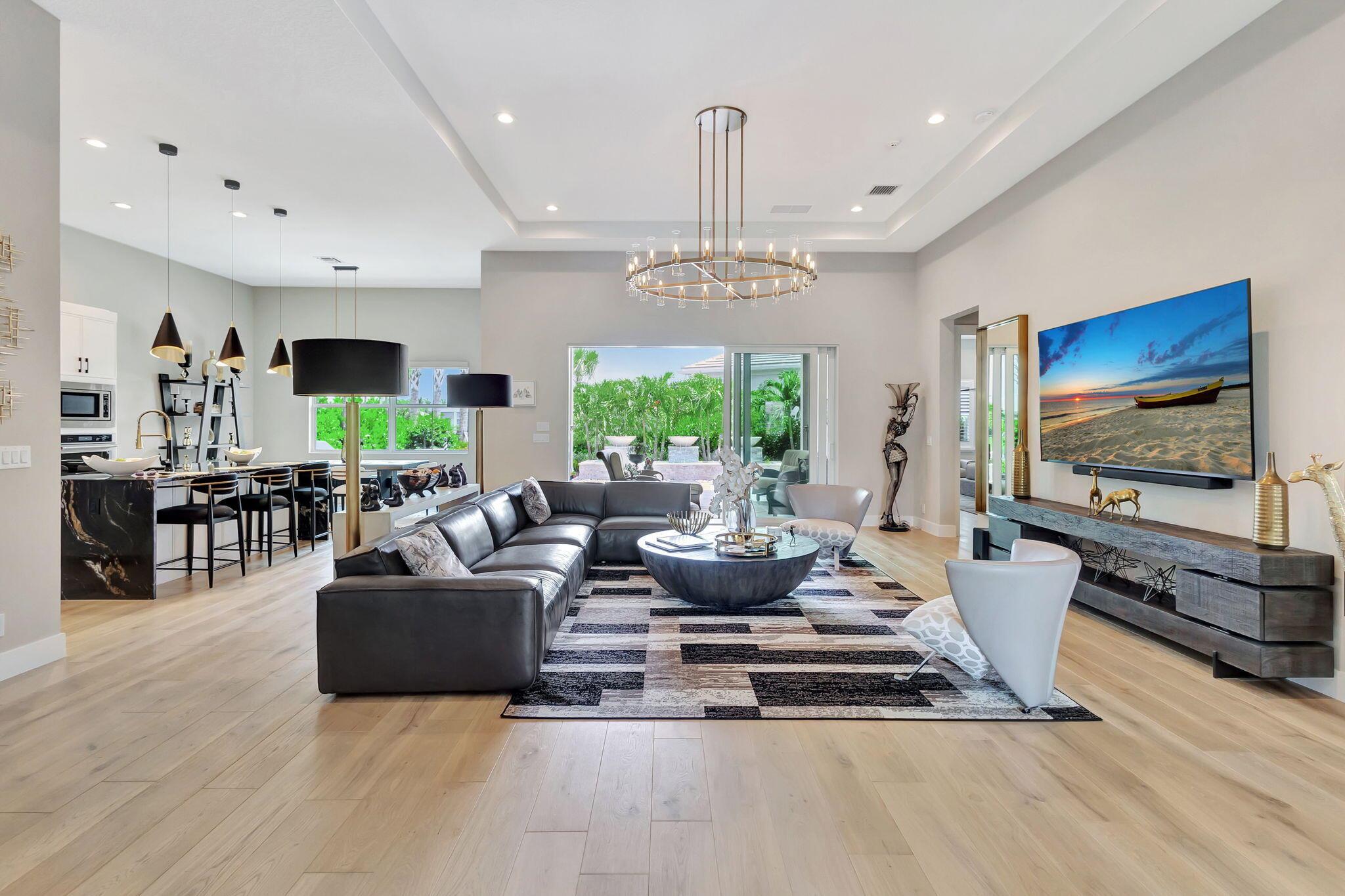 Stunning 3-bedroom, 3 bath and office single story home nestled in the premier Regency neighborhood located in the Avenir Community in Palm Beach Gardens. This beautifully designed home spans 2,729 sq ft of living space and features, impact glass throughout, volume ceilings, warm wood flooring with every upgrade imaginable. The expanded Great room with transition windows offers an abundance of natural light and serene vistas, an intimate space for relaxing or entertaining. The gourmet kitchen boasts upgraded appliances, an oversized island, spacious breakfast nook and tranquil views of the outdoor paradise. The luxurious expanded primary suite is a true retreat with views of the outdoor water features and lush landscaping. The primary bath is complete with double sinks, a soaking tub, a
