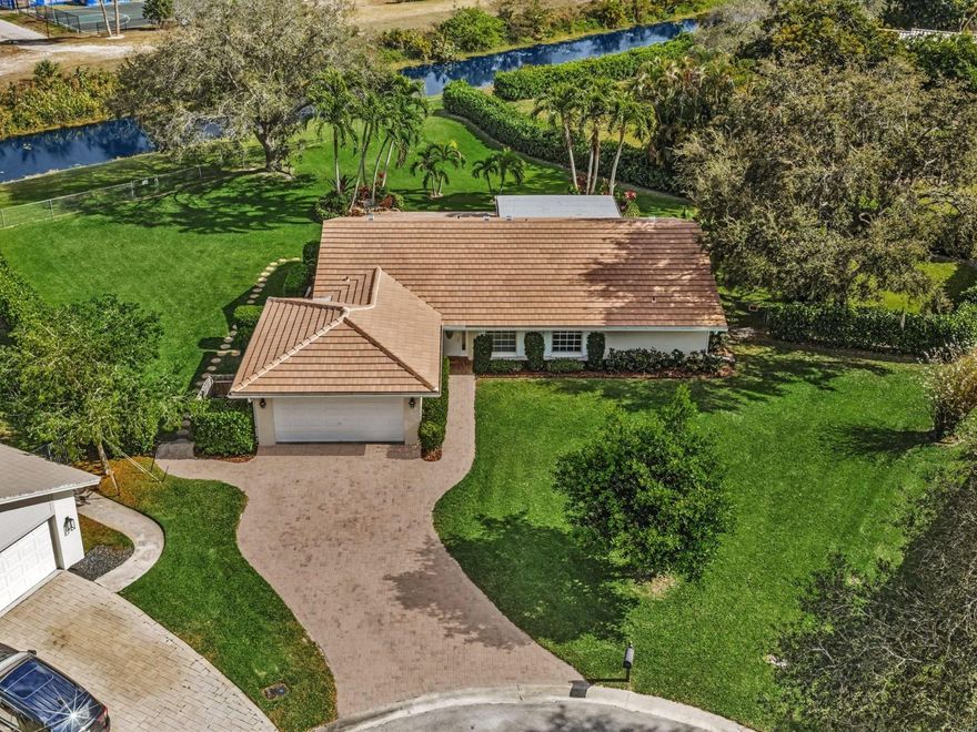 RARE OPPORTUNITY! One-story waterfront pool home on an oversized 17,292 SF fenced lot located on a quiet cul-de-sac in the heart of Coral Springs. NEW ROOF (2025) with warranty and new gutters. Paver driveway,  walkway, & patio. Freshly painted interior and exterior. Hurricane Shutters.This home offers a flexible layout with a spacious great room, dining area, and living room. Split bedroom plan provides privacy. Updated primary bathroom. Additional upgrades include a new hot water heater, new washer and dryer, French doors, & crown molding.The kitchen features tall cabinets, an open pass-through, and extra refrigerator in the garage. Open pool was resurfaced with Diamond Brite (2025), creating an ideal outdoor space for entertaining, play, or future expansion. Generator ready! NO HOA.
