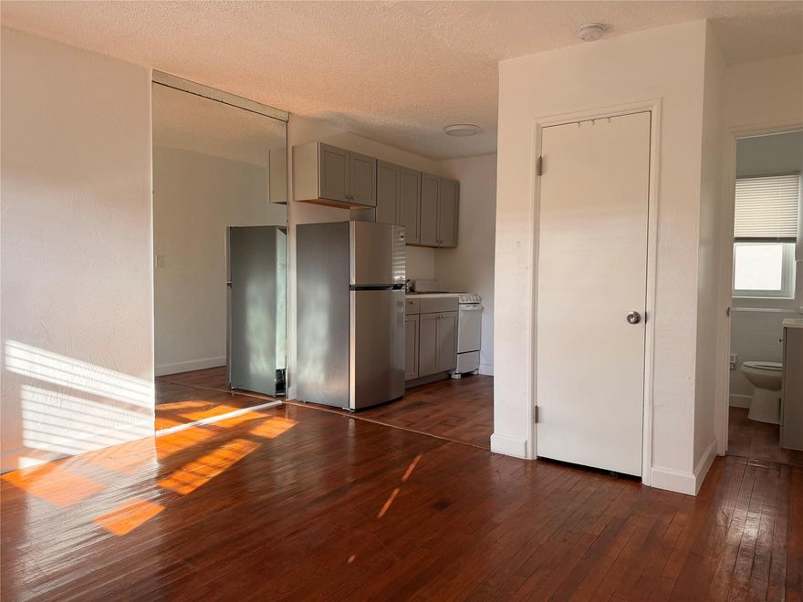 Cozy and bright studio apartment located in the heart of Hollywood, FL! Featuring gleaming hardwood floors and a functional layout, this unit offers a separate kitchen with modern cabinetry, full-size refrigerator, and ample storage space. The living area boasts natural light through large windows with charming views. The retro-inspired bathroom is well-maintained with colorful tile accents. Additional highlights include built-in air conditioning and a mirrored wall for an open feel. Conveniently located near shopping, dining, and entertainment, this apartment is perfect for urban living. Pets welcome, no aggressive breeds.