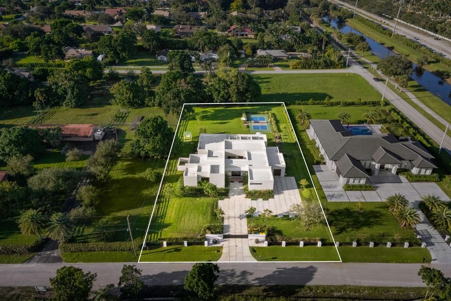 Experience the ultimate South Florida escape at this Modern Hacienda. One-of-a-kind! This luxurious 4-bed, 5-bath, gym, office home blends modern elegance with resort-style amenities for an unforgettable stay. Lighted Pickleball Court–Play day/night on your private court. Golf Practice Cage/Ping pong table. Relaxing sauna, outdoor shower and spectacular heated pool/spa. Expansive patios/grill make this the ideal setting for family gatherings or quiet evenings under the starts. Spacious interiors/fully equipped gourmet kitchen. 20 minutes to Fort Lauderdale Beach and airport. Enjoy quick access to Miami or Boca while still feeling a world away from it all. Whether you’re seeking a private retreat, an active family getaway, or a relaxing staycation, this Modern Hacienda is the perfect home.