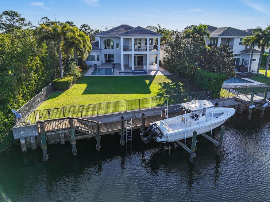 Commanding an extraordinary position along a private canal with sweeping, direct Intracoastal views, this stunning waterfront estate embodies the pinnacle of Palm Beach luxury and maritime living. With a 70-foot private dock, Hi Tide Topless 12,000 lb boat lift, and capacity for a 65-foot yacht or multiple vessels, the residence offers effortless deep-water access with no fixed bridges, just moments from the Atlantic. Perfectly situated on a premium cul-de-sac homesite within the exclusive, guard-gated enclave of Frenchman's Harbor, the property delivers both exceptional privacy and breathtaking panoramic vistas—an unmatched sanctuary for the discerning boating enthusiast. The estate's prime canal-front vantage point provides unobstructed sight lines down the waterway and an uncommon feeling of openness rarely found in South Florida. Spanning over 5,000 square feet, this rarely available Delena model welcomes you with a grand double-door entry into a dramatic 24-foot foyer, where walls of glass frame tranquil water views. A sculptural staircase and sunlit interiors establish an atmosphere of elevated coastal sophistication throughout.

Designed for intimate living and grand-scale entertaining alike, the chef's kitchen is appointed with Wolf and Sub-Zero appliances, custom cabinetry, and an expansive waterfall island. The space opens seamlessly into the living and dining areas, where sliding glass walls dissolve the divide between indoors and out. Beyond lies a resort-style lanai featuring a Twin Eagles summer kitchen, covered entertaining pavilion, and a sparkling pool with sun shelf and spa, all overlooking the manicured grounds and shimmering Intracoastal backdrop.

The main-level primary suite is a serene retreat offering dual walk-in closets, a spa-inspired bath with soaking tub and oversized shower, and an adjoining private den ideal as an office, nursery, or fitness space. The first floor also includes a guest suite with private bath, formal living and dining rooms, a powder room, and a dedicated officeeach space curated with refined balance and timeless elegance.

Upstairs, a spacious loft connects five additional bedrooms, including a versatile bonus suite with its own ensuite bath, perfect as a media room, guest quarters, or lounge. French doors reveal an expansive terrace capturing spectacular sunset views over the Intracoastal, creating an exquisite setting for al fresco dining or evening cocktails.

Additional luxuries include a three-car garage with epoxy flooring, extended driveway, impact-rated windows and doors, and a dedicated pool bath.

Set within Frenchman's Harbor, one of Palm Beach County's most prestigious waterfront enclaves, owners enjoy 24-hour manned security, exceptional deep-water dockage, and proximity to world-class beaches, golf, fine dining, and luxury shopping.

With its unrivaled vantage point, rare dockage capabilities, and architectural sophistication, 13965 Willow Cay Drive stands as a true statement of distinction, a legacy estate of exceptional caliber on South Florida's Gold Coast.