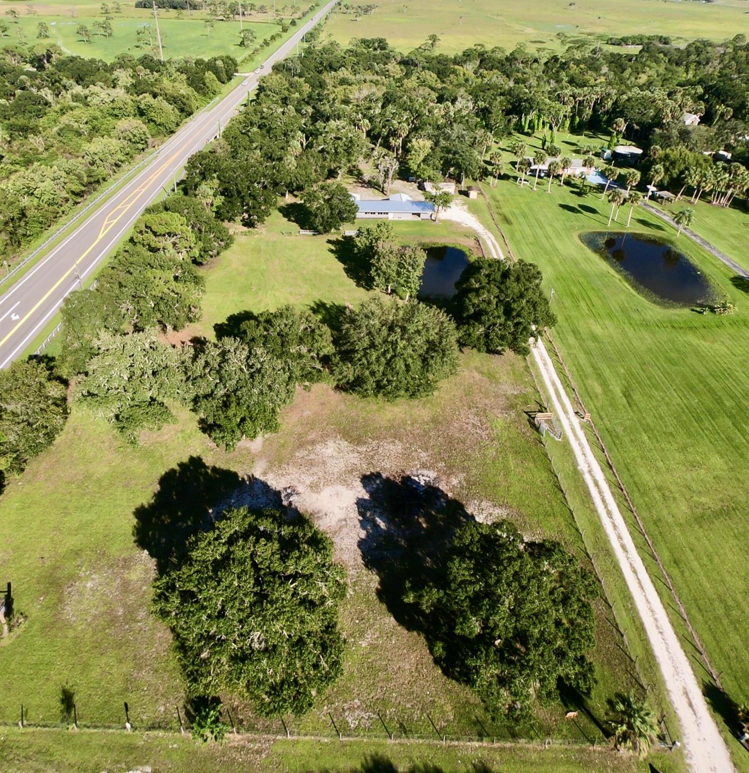 *5 ACRES* Rustic charm meets modern updates in this fully remodeled 3BD/2BA home on 5 acres. A brand-new metal roof, gorgeous new kitchen, and walls of windows fill the home with natural light. Set back off the road, it features a long gravel drive, open carport, and U-shaped layout with a huge patio at its heart. Enjoy a shady oak hammock out front, a pond by the house, and a creek winding through untouched Florida woods out back. Room for all your animals, toys, and even your RV.