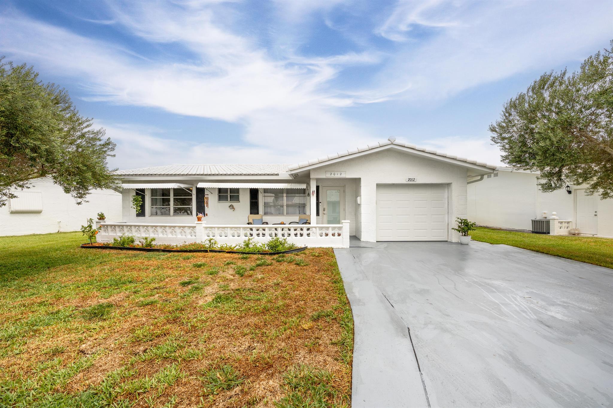 Meet your new home & the beginning of your next chapter in life! Located in the sought-after Palm Beach Leisureville 55+ community, beautifully updated & fully renovated in 2021 offering comfort & style. Features include a double driveway, new high-impact front door (2023), new Trane AC (2023) & a large screened porch w/hot tub included. You'll love the Italian marble floors throughout, updated kitchen and bathrooms, H/W heater (2021), and LG W/D. Enjoy the Leisureville lifestyle with 3 clubhouses/pools, Fitness CTR, 18-hole public golf courses nearby, social activities, and more--all with a low HOA including lawn care and cable! This home is move-in ready--just bring your toothbrush and start living the good life in paradise