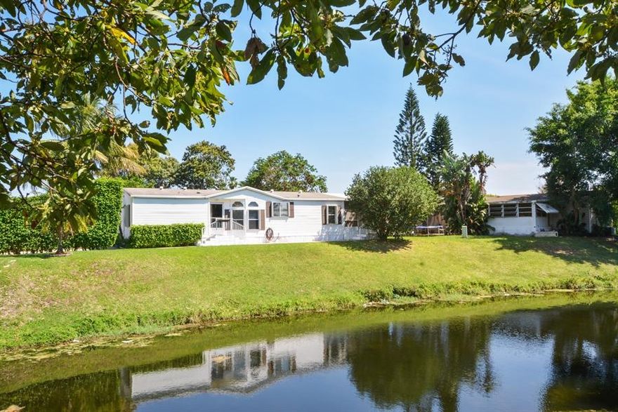 Beautifully maintained double wide manufactured home in desirable Sandalfoot Cove with meandering views of the canal.  Spacious and bright 3 bedroom home with screened patio overlooking wide canal. Split bedroom plan. Large kitchen, vaulted ceilings and open living area. Master bedroom, Master bathroom offers a roman tub and separate shower. Two guest bedrooms, guest bath, laundry area, screened patio, fabulous canal vistas. You own the lot. Roof 2012 with newer AC and Water Heater.  Partial hurricane shutter protection. Close to shopping, major roads and beaches.  Look no further, you won't be disappointed!