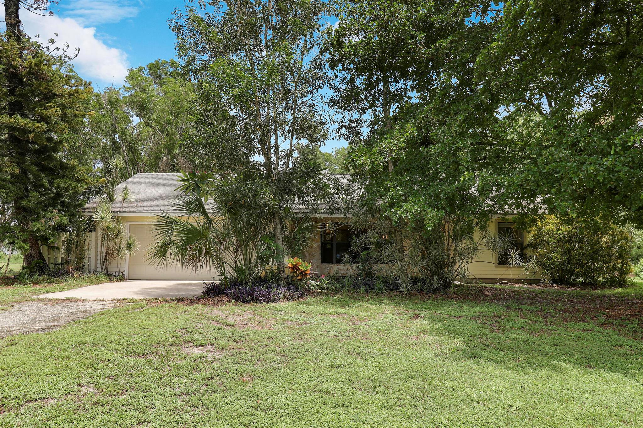 SERENE PRIVATE PROPERTY featuring 1.25 ACRES of LAND for your enjoyment in making this your home. NO HOA FEES which allows for endless opportunities for this property. This home is setback from the road with NICE TREES and a LARGE POND in the backyard. PLENTY OF SPACE for ENTERTAINING. This property features 3 bedrooms/2 bathrooms in a well desired area of JUPITER FARMS. SPLIT OPEN FLOORPLAN. BEAUTIFUL KITCHEN cabinets with upgraded countertops. DID I MENTION THE LARGE SCREENED IN PORCH OVERLOOKING THE BACKYARD and POND?