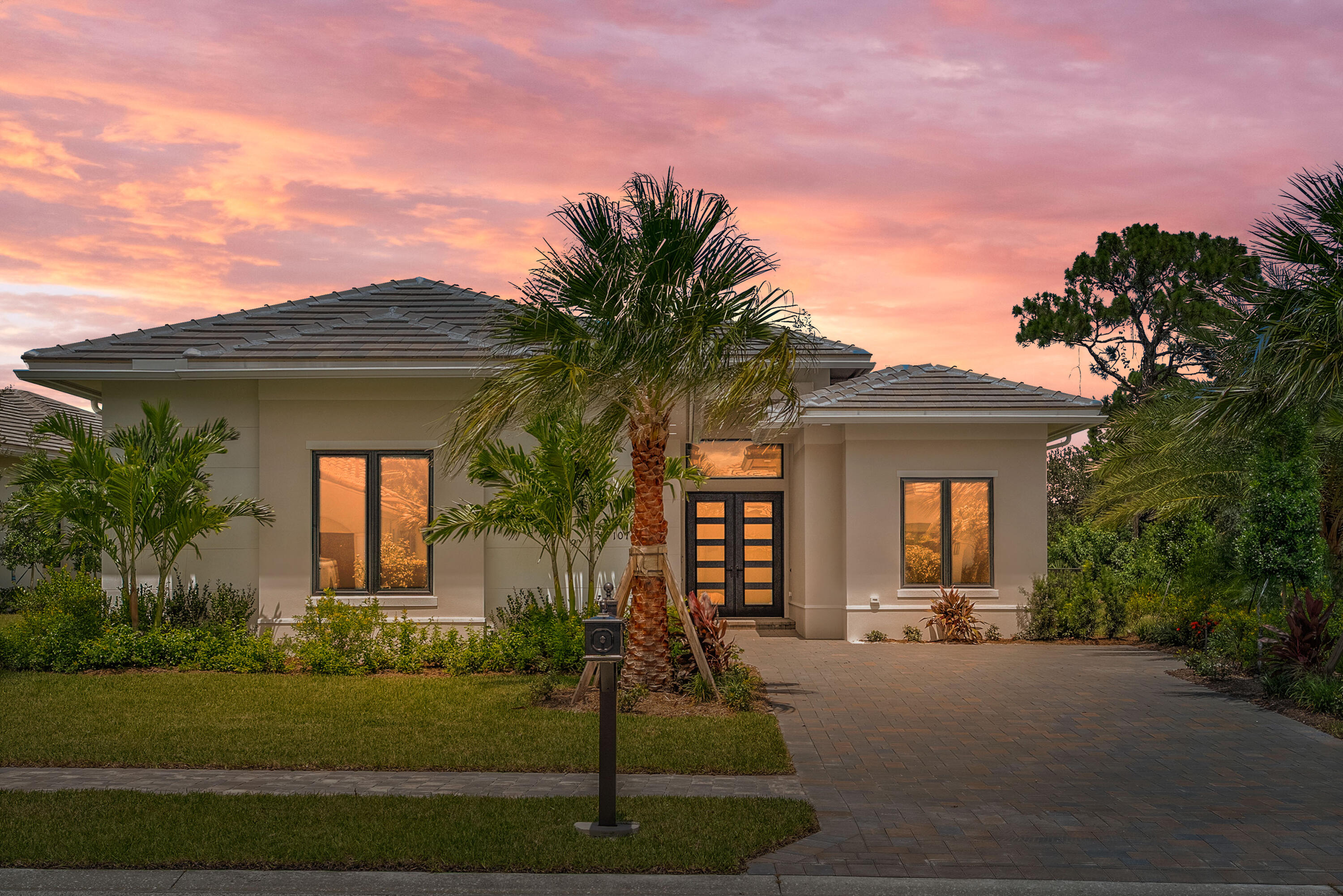 Located in the prestigious Tesoro Club, this exceptional residence features a striking contemporary front elevation. Based on the Stella model, this residence boasts impressive high-volume ceilings and a chef's kitchen with top-of-the-line Cafe appliances, including a spacious 42-inch built-in refrigerator. The kitchen is designed for functionality and style, featuring an oversized central island with a stunning 2.5-inch waterfall edge, a walk-in pantry with custom shelving, and stacked cabinets above a natural gas cooktop. The great room is a focal point, enhanced by an electric fireplace surrounded by elegant tiling, creating an inviting and sophisticated atmosphere. The backyard is perfect for entertaining, with a luxurious pool and travertine paver patio that elevates outdoor living!