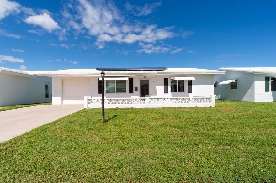 Welcome to this updated Holiday model single-family home in the 55+ community of Palm Beach Leisureville. This 2 bedroom, 1 bathroom, 1-car garage residence offers 1,011 sq. ft. of living space (1,330 sq. ft. total) with impact windows, a solar panel system, new A/C, diagonal tile floors, and a new kitchen with cabinets, appliances, and vinyl flooring. The exterior features a stamped concrete 2-car driveway for added curb appeal. Leisureville residents enjoy three clubhouses, heated/cooled pools, saunas, steam rooms, a fitness center, hobby shops, and a private 18-hole par-three golf course, all included along with free golf and lawn care.  Ideally located near beaches, shopping, dining, and cultural destinations, with easy access to I-95, the Turnpike, Brightline, and two airports, this home blends comfort, convenience, and lifestyle.