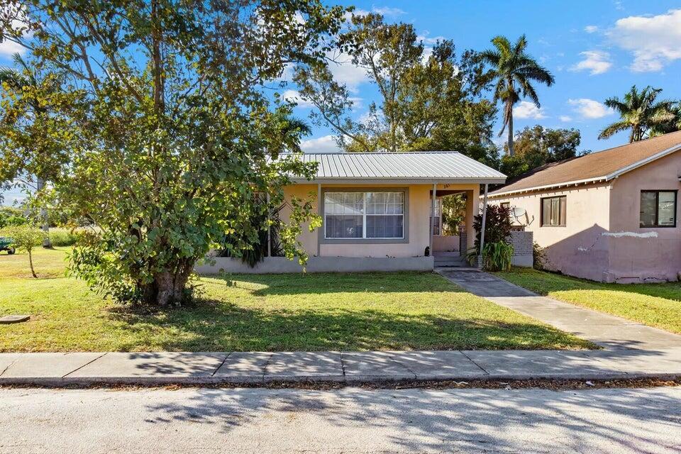 This charming 2-bedroom, 1-bath CBS home is situated on one of Pahokee's most desirable neighborhoods, Walk to the Marina--or walk along the majestic trails of Lake Okeechobee. The home has it all! Several recent upgrades, including a new air conditioning system (2020), a newer roof (2017), updated flooring (2020), and a beautifully renovated bathroom with new tile, sink, toilet, and faucets (2024). The newer kitchen is equipped with modern appliances.Outside, you'll find a spacious Workshop or Podcast room with running water, plus its own electricity. Perfect for a first time home or first time investment.