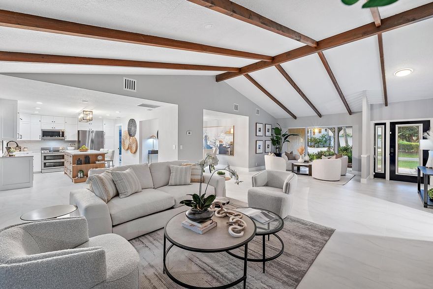 Own this stunning, fully renovated home in time for the 2025/2026 season. Located in the highly sought-after PGA National, this spacious 3-bedroom, 2-bathroom residence sits on a rarely available .30-acre lot and offers over 2,100 sq. ft. of beautifully upgraded living space. Complete with brand-new 2025 impact windows, this home blends modern luxury with true South Florida indoor/outdoor living.Step inside to vaulted ceilings, exposed beams, and new 24'' x 48'' Andover White porcelain tile flooring with a matte finish throughout the main living areas. Multiple sliders open fully to a large screened lanai, creating a seamless flow between the indoor and outdoor spaces.