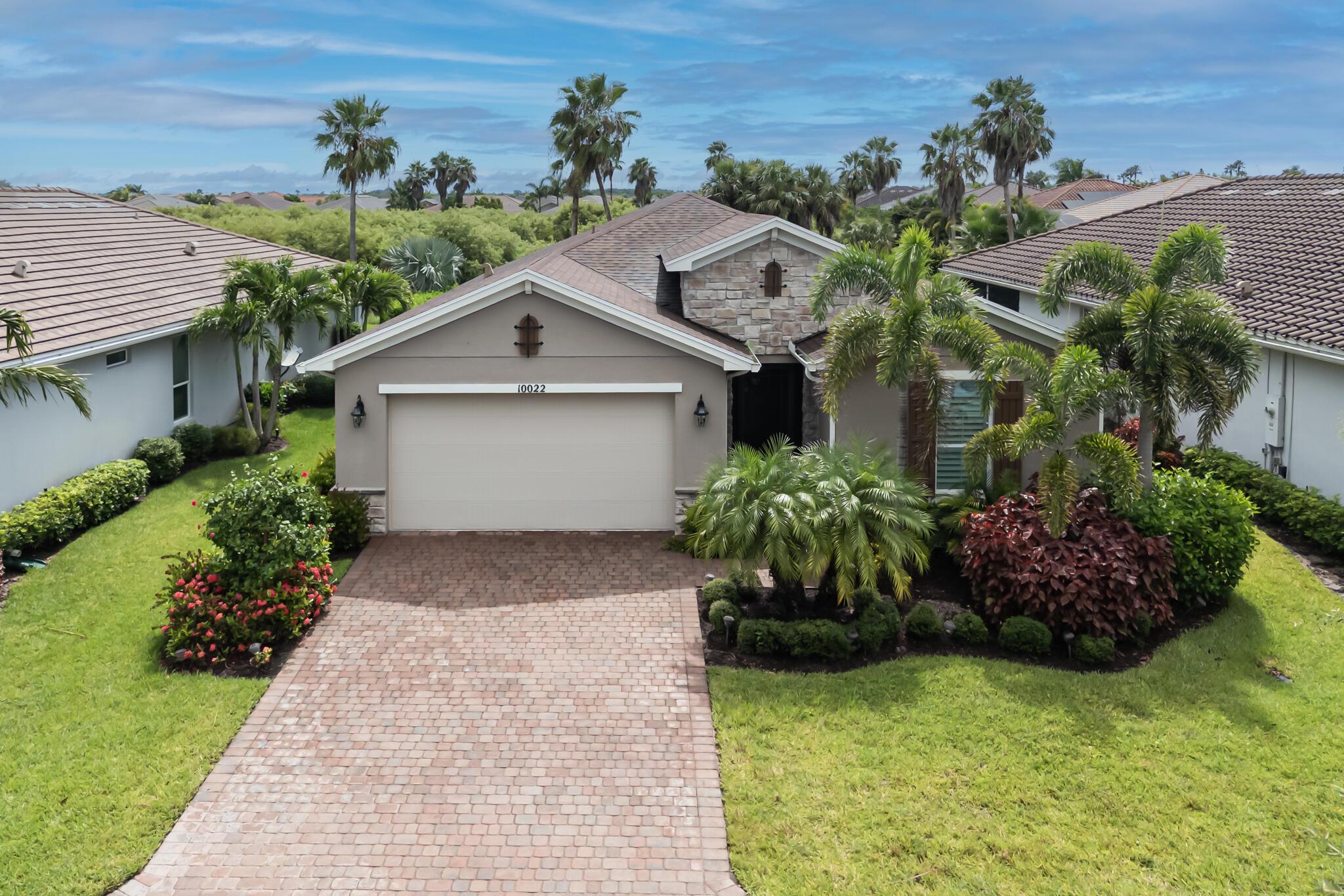 Welcome to this meticulously maintained 2-bedroom, 2-bath home with a versatile den/office, located in one of Tradition's premier active adult communities. This move-in ready residence features tasteful upgrades throughout, including elegant plank tile flooring, crown molding, neutral color palette, and plantation shutters for a refined, cohesive look.The heart of the home is the stunning designer kitchen, complete with a large gathering island, granite countertops, subway tile backsplash, gas cooktop, double wall ovens, and an oversized walk-in pantry with custom built-ins. Entertain with ease thanks to the convenient butler's pantry perfect for a coffee station or cocktail setup.The spacious primary suite offers a tray ceiling, a generously sized walk-in close