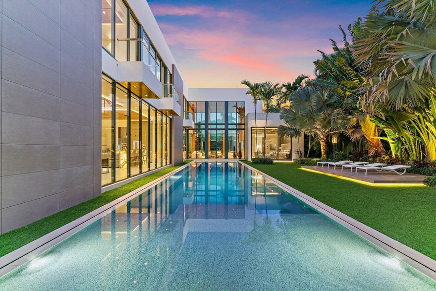 A Masterpiece of Modern Luxury, this residence represents International Style architecture at its finest, defined by clean lines + organic materials. Outstanding Admirals Cove location on coveted Spyglass Lane, just steps from the wide Intracoastal Waterway. Nestled on .49 scenic acres between golf course + 100'  Waterfront, this home elevates living with every detail crafted to perfection. The striking facade merges modern precision with enduring quality + durability. Step inside to a grand open space graced by double height walls of glass. Interior space offers several living/gathering areas, perfect for entertaining or quiet enjoyment. The contemporary chef's kitchen features Italian cabinetry + backlit cristallo counters. Highest end appliances and a butlers pantry finish this perfect  space. Beyond the kitchen is an elegant family room as well as a generous recreation area, complete with bar and a state of the art golf simulator.  The secluded Owner's suite is serene + tranquil with its own spa inspired bath and stylish wardrobe room.  An additional downstairs bedroom and three upper guest rooms are all grand in size and thoughtfully designed.  The upper level living area is perfect for guests.  From the moment you enter this home, you will be touched by thoughtful design sophistication - inside + out.  The outdoor areas areas bask in verdant greenery.  The pool + surrounding areas are a breathtaking oasis of comfort + luxury.   A sauna bath and outdoor fireplace enhance the oversized spa + lap pool.  Upper and lower sun decks provide great space for enjoying fine Florida living. For Boaters: New deck + dock w/ 16,000 lb lift ... Easy Intracoastal + Ocean Access with No Fixed Bridges.   An air conditioned 3.5 car garage + spacious outdoor motor court offer added convenience.  The Admirals Cove Club is one of the most secure and prestigious in all of Florida, offering 45 holes of golf, two grand clubhouses and a world class marina with floating docks.  Both clubs offer exquisite dining experiences as well as rooms for private functions.  A separate building houses the state of the art fitness center and full service wellness spa.   Tennis + pickleball enthusiasts will always find an open court.  Additional amenities include a kids club, dog park, salon, bank and the private Admirals Cove hotel reserved for members and their guests.  Outside the gates, you are just minutes away from the areas best beaches, shopping, dining, educational + cultural venues.  25 minutes to Palm Beach Island or the PB Int'l airport.  A beautiful lifestyle awaits you...