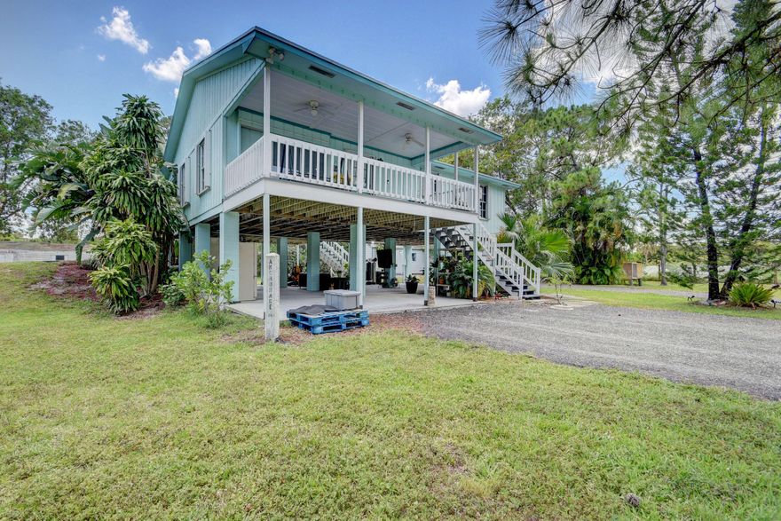 This diamond 2/2 built on stilts has unlimited possibilities and sits on 1.29 acres. Plenty of room for a pool or storage for your boat or RV. Natural light glistens throughout. The two balconies enhance and add to the homes charm. The roof was replaced in 2018, all windows and doors are hurricane protected, water is filtered thru a Puronics water filter (new), 2 shed are present; 1 could be your he/she shed, Appliances are stainless steel, Additionally there is a Pur-O- Max water filter in the kitchen,.  There is an agreement in place for FP&L to bury the electrical lines at NO cost to home owner.