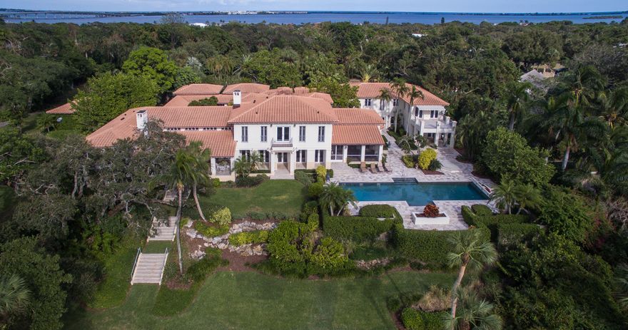 Sitting high above the river on 3+ acres offering privacy and plenty of room to roam on the estate caliber grounds and your own inland boat basin with 300' of river frontage. The sprawling main home feels palatial, yet not overwhelming and all of the bedroom suites are thoughtfully placed to offer plenty of privacy. Stroll through the tranquil courtyard before entering into a grand living room overlooking the river. As you walk through the gallery you'll discover a library, richly accented with black walnut built-ins, a formal dining room, gourmet kitchen, breakfast room, a fully equipped gym...there are just so many rooms to explore! Top it off with a stand-alone movie theater with seating for 15 plus a 2 bedroom, 2 bath caretaker/guest house. Truly a rare find in beautiful Martin County.