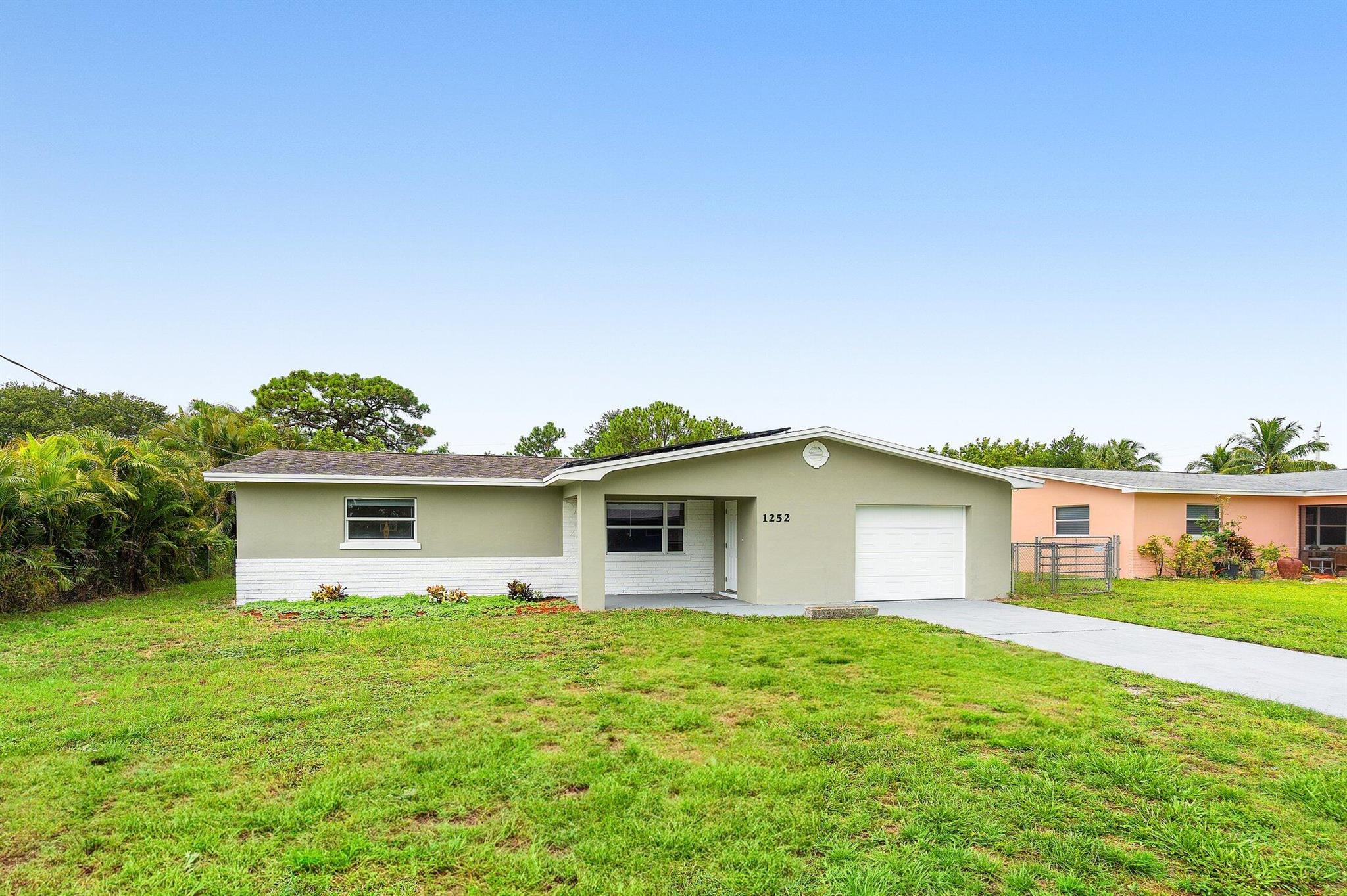Renovated 2 bedroom, 2 bathroom CBS home in desirable Jensen Beach with a spacious yard. Features new luxury flooring throughout, a modern kitchen with white cabinets, granite countertops, and stainless steel appliances. Both bathrooms have been updated with new vanities, tile, and fixtures. Impact windows, AC 2019, and a brand-new roof coming soon make this home move-in ready and worry-free!