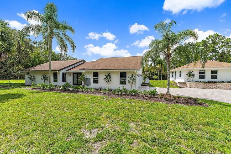 Set on a fenced 1.25-acre lot in Jupiter Farms, this unique rental opportunity offers two separate residences, a private pool, and the flexibility of no HOA living. Featuring a total of 5 bedrooms plus a den/office, 3 full bathrooms, and 2 half bathrooms, the property combines updated interiors with expansive outdoor space in one of Jupiter's most sought-after acreage communities. The main house features 3 bedrooms plus a den/office, 2 full bathrooms, and 2 half bathrooms, highlighted by a renovated kitchen with a massive waterfall island, bar seating, butler's pantry, and wet bar designed for entertaining. Large bedrooms, generous closet space, skylights, impact windows and doors, fireplace, updated lighting, new flooring, and fresh interior finishes create a bright and functional living environment. The detached guest house offers an additional 2 bedrooms, 1 full bathroom, living space, and added flexibility for guests, extended family, or a private work-from-home setup. Outside, the property offers a private pool, fruit trees, a two-car garage, and wide open space rarely found in Jupiter rentals. Landlords will cover pool maintenance, lawn care, HVAC servicing, and water filtration system maintenance, creating a more seamless and low-maintenance living experience for tenants. Located within the highly desirable Jupiter Farms community with top-rated schools nearby, this property offers convenient access to local parks, equestrian trails, beaches, dining, and major commuter routes while maintaining the privacy and freedom of acreage living. Pets considered on a case-by-case basis with a non-refundable $250 pet fee per pet. First month, last month, and security deposit required. Rentspree application to be completed by all applicants.