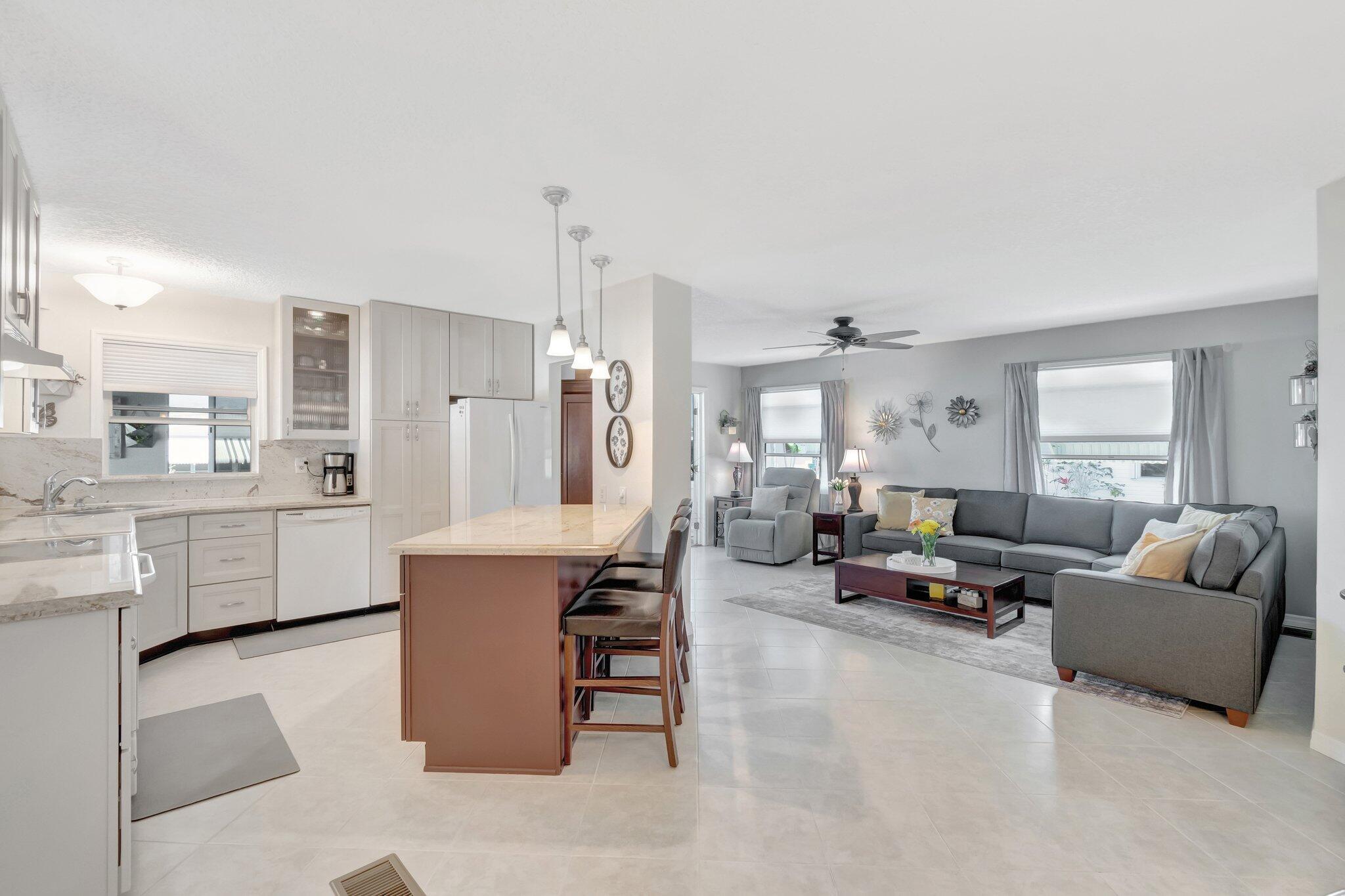 THE CROWN JEWEL OF JAMAICA BAY with almost 2,000 sq ft! Upon entering you will immediately notice the pride of ownership in this 2 bed / 2 bath home with a raised Florida room and additional lanai providing plenty of living space on corner lot. Updates in this home include, a STUNNING open kitchen with extended cabinets, granite countertops and backsplash, island with additional storage, pull out drawers, oversized deep sink, engineered hardwood flooring and crown molding in bedrooms, drywall interior, updated vanities in bathrooms, NEW windows encased in molding with new pleated shades, updated fixtures throughout, freshly sealed roof (March 2025), BRAND NEW tankless hot water heater, oversized shed with through access, laundry room provides washtub, all surrounded by lush landscaping!