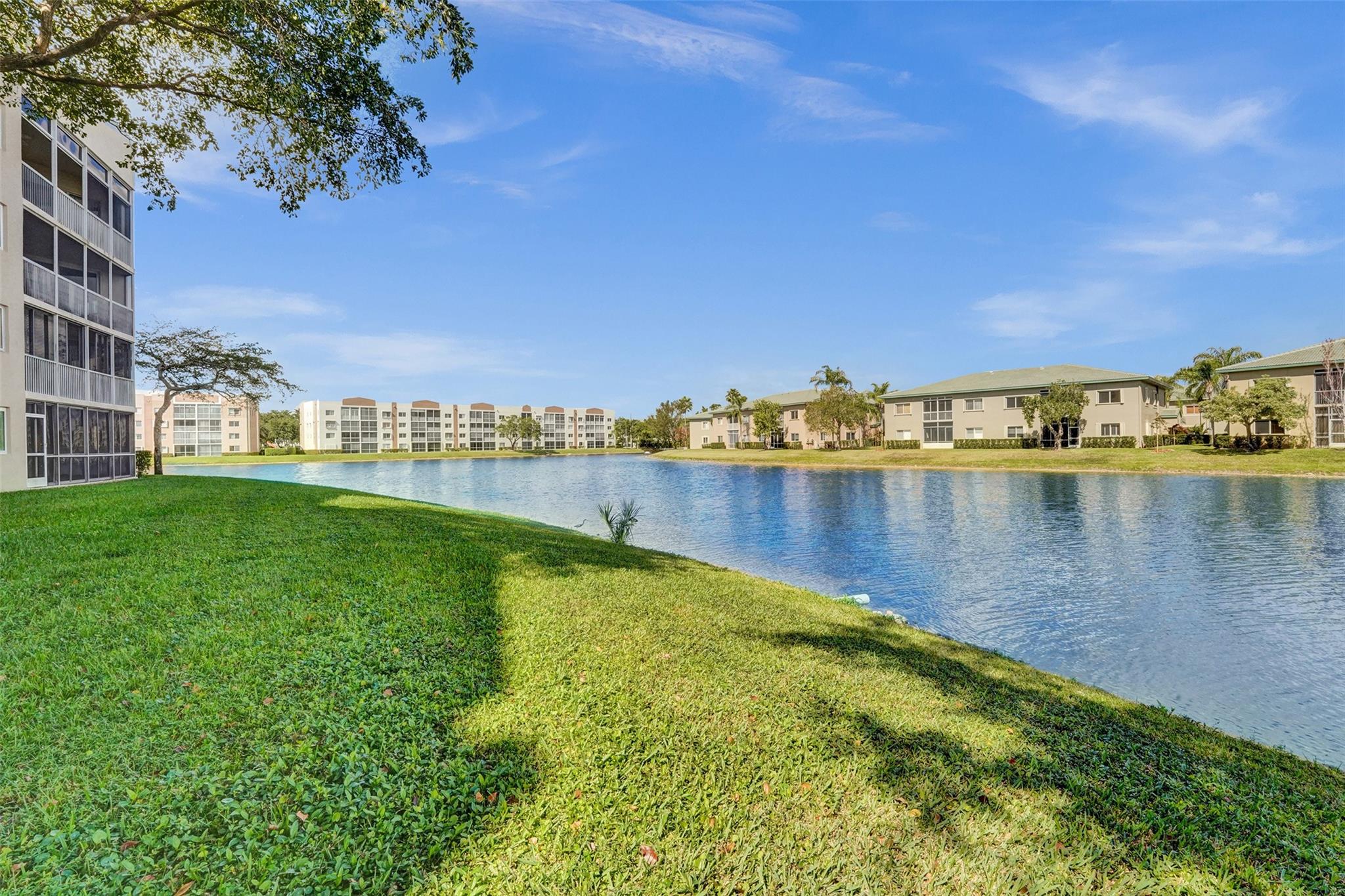 Charming Waterfront First-Floor Unit – 55+. Motivated seller.
Don’t miss the opportunity to own this beautiful, well-maintained waterfront unit. This home features a private, gated front patio perfect for gardening and relaxation. Large storage room. Conveniently located near the mail and garbage area. Assigned parking space in front of unit. The back patio offers peaceful views of a wide lake and fountain. Inside, you’ll find a neutral décor with freshly painted walls and professionally cleaned grout. Unit comes equipped with a full-size laundry room. Home is storm-ready with accordion shutters. The neighborhood is secured by double manned gates. This lovely unit is the perfect combination of comfort, convenience, and security.