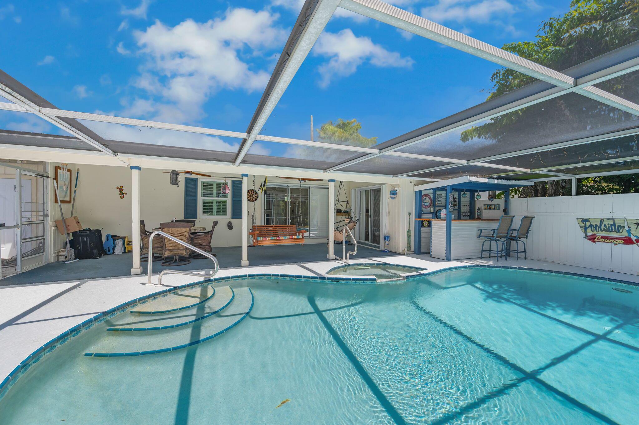 Ready to move in 3 bedroom, 2 bath home in Sandpiper bay community. Screened in heated pool with custom tiki hut and hot tub. Granite kitchen with stainless appliances. 3rd bedroom has murphy bed. 1 car garage with office/exercise room. Newer Instant hot water heater. Short distance to the upcoming upscale resort and Freedom rental boat dockage. You'll enjoy beautiful views and walking trails out your back door. Hurricane protection includes: 2020 metal roof and impact window and accordion shutters along with poured concrete walls.  The patio comes complete with a Lloyd Flanders patio table set at a $8,000 value.