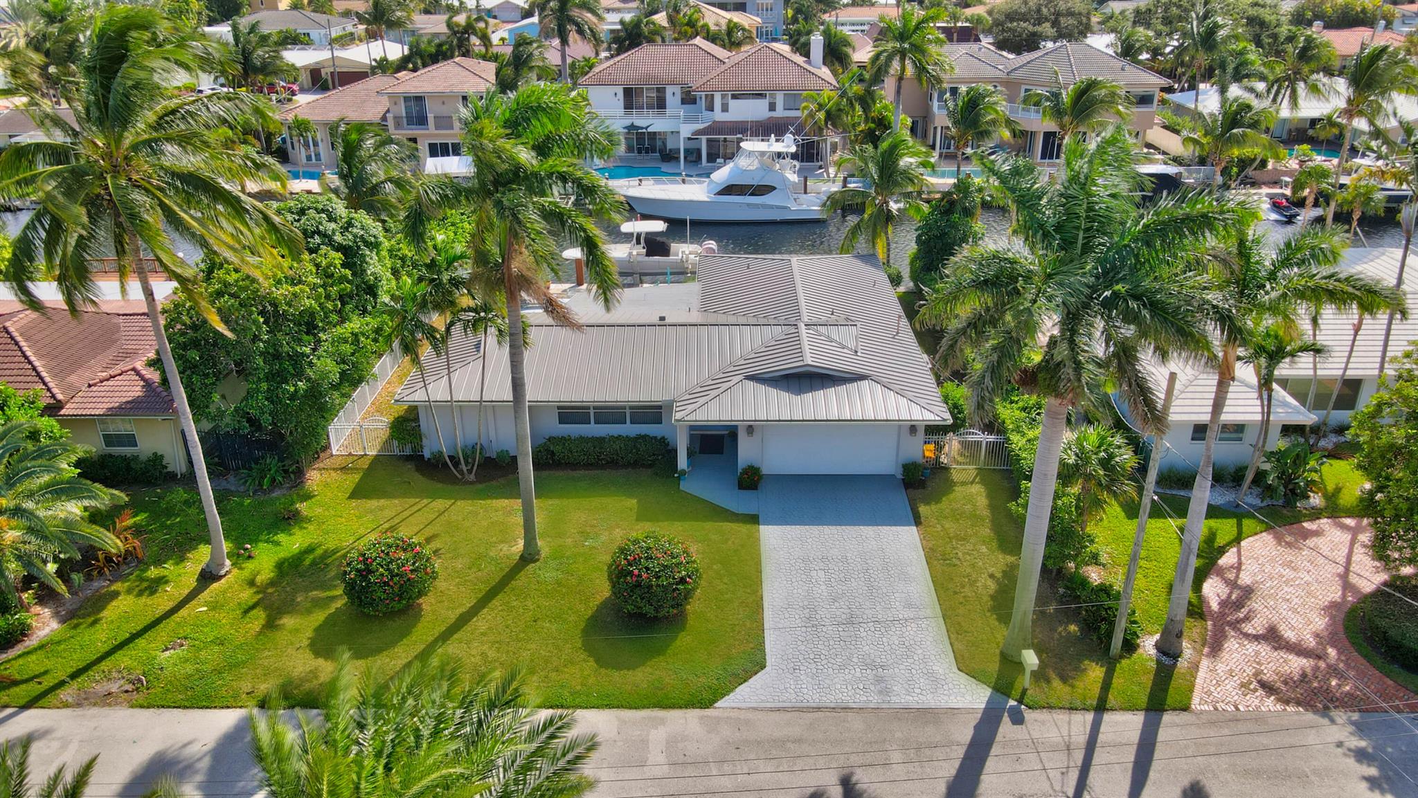 Embrace South Florida luxury in this remodeled ranch home with 85' of deepwater frontage, 60' dock, 13,000-lb boat lift, shore power, and no-fixed-bridge ocean access. Southern exposure delivers SE breezes and vibrant light. The open-concept layout boasts a sleek kitchen with a grand island, a dining area with a chic built-in bar, and a primary suite with serene water views, a spa-like bathroom, soaking tub, and shower. The split-bedroom design offers privacy. Move-in ready with CBS construction, 2023 metal roof, impact windows, 2022 AC, and appliances. Nestled in non-HOA Bel Marra, steps from Boca Raton and Delray's Atlantic Avenue, where lots fetch $2-2.5M. Your dream waterfront haven awaits!