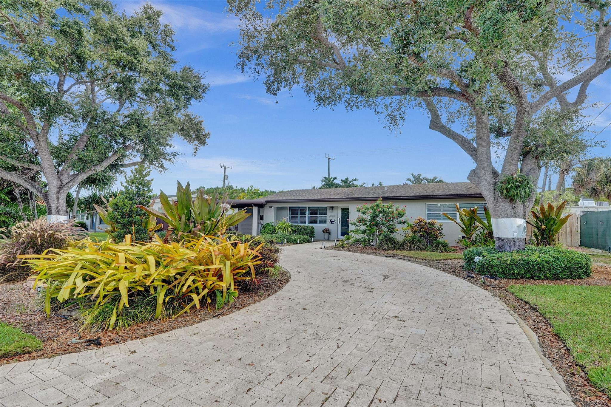 Beautifully updated 3-bedroom, 3-bath home featuring two split master suites with walk-in closets and spa-style baths. The open living area boasts high ceilings, porcelain tile floors, and a chef’s kitchen with granite countertops, island, and stainless steel appliances. A breakfast nook overlooks the heated pool with travertine patio, creating the perfect indoor-outdoor flow. Additional highlights include impact windows, circular driveway, covered carport, camera system and a fast EV charger.
