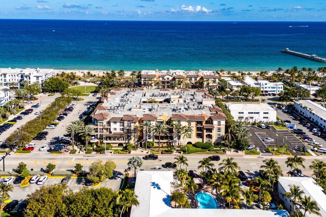 Discover coastal living at its finest in this bright 2-bedroom, 2.5-bath Villas by the Sea Condo, complete with a spacious den. The expansive master suite boasts floor-to-ceiling impact windows, a generous walk-in closet, and a luxurious en-suite bathroom featuring a jetted tub, oversized rain shower, and dual vanities. Soaring 10-foot ceilings enhance the airy ambiance throughout. Enjoy modern comforts with a recently upgraded AC unit, fresh paint, and move-in-ready condition. This coveted property includes two garage spaces and resides in Lauderdale-by-the-Sea's newest complex. Indulge in exclusive amenities like a private beach club with kitchen and cabanas, a heated pool, spa, BBQ area, and more.
