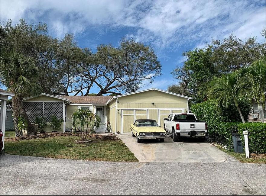 Rare Find. Only 5 homes in the whole neighborhood with a garage and this house has a TWO CAR GARAGE with private 2 car driveway in the  Meadows community in Palm Beach Gardens. The Kitchen was updated in 2019 with granite counter tops and stainless steel appliances. Washer and dryer located in laundry closet off the kitchen. Durable Laminate wood floors throughout the house in soft gray tones which match the cookies and cream granite counters in bathrooms and kitchen. Split floor plan with 2 bedrooms/ 1 bathroom on one side and master suite on the other. French doors lead to your master suite complete with roman tub and stand alone shower.  Screened Porch. Cul-de-sac location. The land is leased and monthly fee of $1400 includes water, cable, property taxes, maintenance of the pool,