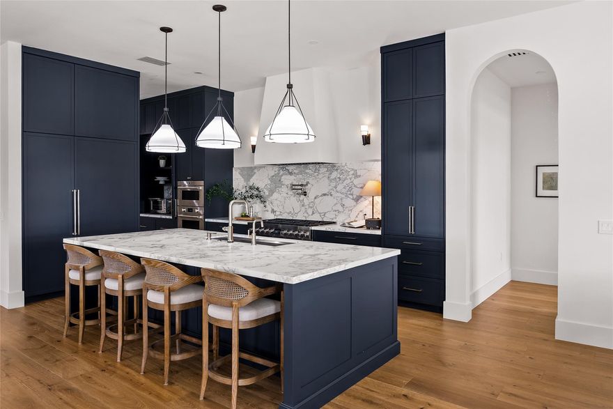 Step into a residence where every detail has been thoughtfully curated to balance modern functionality with timeless design. At its heart lies a bespoke kitchen, enveloped in Italian Statuario Belgia marble with a striking three-foot backsplash, complemented by a Sub-Zero/Wolf appliance suite, handcrafted custom cabinetry, and European white oak hardwood floors that flow seamlessly throughout the home.
The primary suite offers a serene retreat, complete with travertine floors, custom dolomite vanities, walk-in rainfall shower elegantly enclosed by a tailored single pane of low-iron glass, and a two-person soaking tub reminiscent of a luxury spa experience. Outside, enjoy panoramic lake views, a fully fenced yard, and the privacy of a generous one-third-acre homesite.