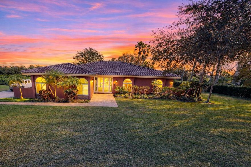 Located in the highly desirable Whispering Pines area of Davie, this beautiful custom home sits on a rare builder's acre corner lot surrounded by mature oak trees and estate-style homes. The property offers the space, privacy, and lifestyle many buyers search for in Davie, Southwest Ranches, and Weston, while still being conveniently located near major highways, golf courses, hiking trails, shopping, and South Florida attractions.This spacious 4 bedroom, 3.5 bath pool home features an open and functional floor plan designed for both everyday living and entertaining. Interior highlights include vaulted ceilings, impact windows and doors, dual A/C systems, LED lighting, and integrated surround sound inside and outside the home.The updated kitchen serves as the centerpiece of the home and includes quartz countertops, new KitchenAid stainless appliances, abundant cabinetry, and a pantry with dedicated coffee bar. The layout flows seamlessly into the main living areas and overlooks the backyard and pool.The primary suite offers a relaxing retreat with an updated spa-style bathroom featuring a soaking tub and spacious layout.Recent improvements include newly installed privacy hedge landscaping along the rear and side of the property, creating a natural green buffer that enhances privacy while maintaining the open feel of the builder's acre lot.Outdoor living is where this home truly shines. The backyard features a resort-style pool with waterfall feature, covered patio, and cabana bath, perfect for entertaining or enjoying South Florida's year-round outdoor lifestyle. The oversized lot offers room for future expansion possibilities, or additional recreational space.Davie is known for its equestrian lifestyle, large estate properties, and top parks, including Tree Tops Park, Vista View Park, and Bergeron Rodeo Grounds, along with miles of equestrian and riding trails. The location also provides convenient access to Sawgrass Mills Mall, Las Olas Boulevard, Fort Lauderdale beaches, and Fort Lauderdale-Hollywood International Airport.This property offers a rare opportunity to own a builder's acre estate in Davie with privacy, land, and modern upgrades.Seller is offering a competitive pricing opportunity with a starting price of $999,900.