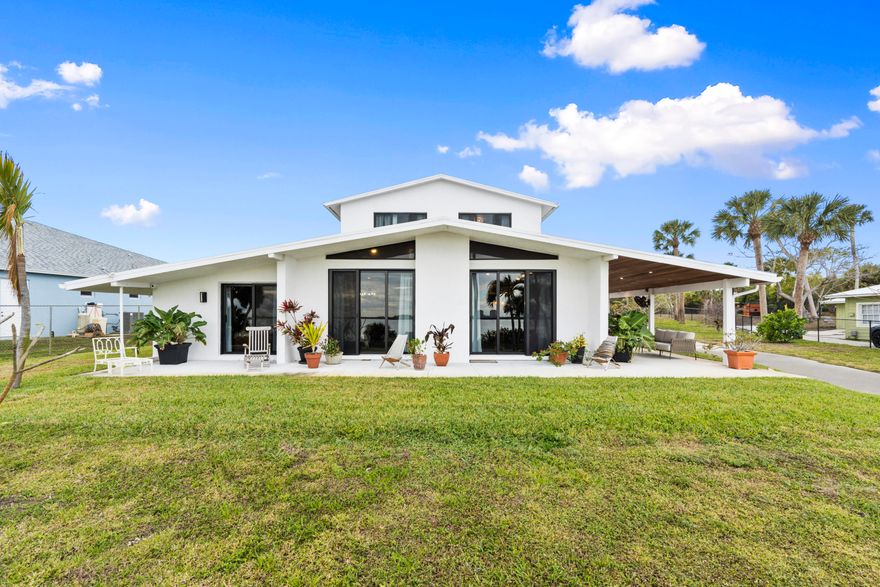 This is what Indian River Drive living is supposed to feel like. Set on 1.15 acres with 95 feet of direct river frontage, this reimagined contemporary estate delivers along one of Florida's most iconic scenic routes. Every inch of this two-story residence blends timeless character with modern luxury across 5 bedrooms, 3 bathrooms, and over 2,700 square feet of living space. Inside, volume and texture take center stage. Soaring cypress plank ceilings and original terrazzo floors ground the home in authenticity. The kitchen is anchored by quartz countertops, an antique island, gas range, stainless steel appliances, open shelving, and a designer tile backsplash. Impact windows throughout capture breathtaking river views from nearly every room. Recent upgrades include a 2024 metal roof, 2025 water heater, 2018 A/C, and a 125-gallon whole-house diesel generator for year-round peace of mind. Upstairs, a fully equipped private apartment offers exceptional versatility with a private entrance, two bedrooms, a full bath, spacious living area, kitchenette, in-unit washer and dryer, and its own porch overlooking the water. Outdoors, a covered patio with a summer kitchen and full outdoor bath is built for effortless entertaining, all set against a stunning riverfront backdrop. The private dock is dialed in with new water lines, 6-gauge electric, and a 20,000 lb. lift capable of accommodating up to a 40-foot vessel. A 2-car garage/workshop, attached 1-car garage, 2022 irrigation system, and a dedicated backyard septic system already in place for a future guest home or RV.