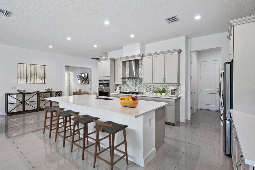 Welcome to Andalucia, West Lake Worth & the Wellington area's best kept secret neighborhood! This modern oasis is conveniently located & highly accessible to the turnpike, shopping, restaurants & ''A'' rated schools. Featuring; 5 bedrooms with 4.5 ensuite bathrooms, open floorplan with a bright modern kitchen (quartz counters & GE Profile Apps), large island, walk in pantry, den (or formal dining room/5th bedroom), huge loft, 3 car garage & ample closet/storage space! Backyard is perfect for entertaining with a 27x12 covered patio, outdoor kitchen, enclosed by retractable screen, overlooking a very private, beautifully manicured landscape & pool. This home is equipped with impact windows & doors, natural gas, tankless water heater, modern 24x24 tile floors & laminate flooring throughout